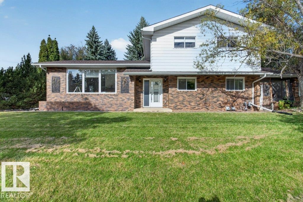 Brick and siding exterior with a pitched roof, front entry door, and multiple windows - #74 22555 Twp Road 530, Rural Strathcona County, AB