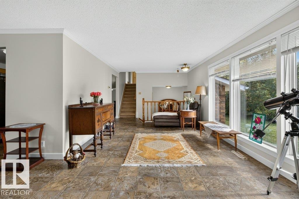 Spacious living area featuring tile flooring, large windows, and crown molding - #74 22555 Twp Road 530, Rural Strathcona County, AB