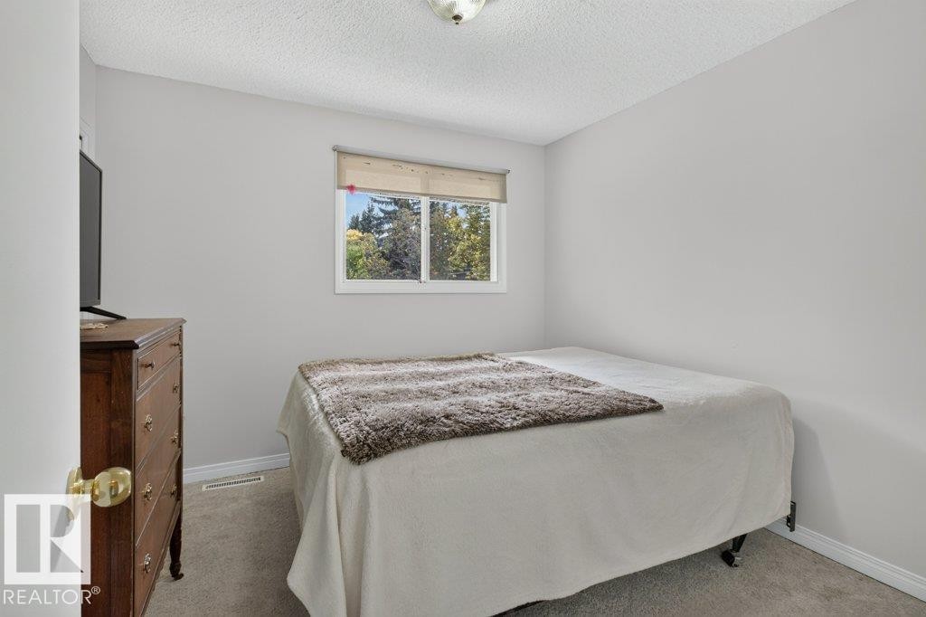 Wall-to-wall carpeting with light gray walls, a window with a roller shade, and a flush mount ceiling light - #74 22555 Twp Road 530, Rural Strathcona County, AB