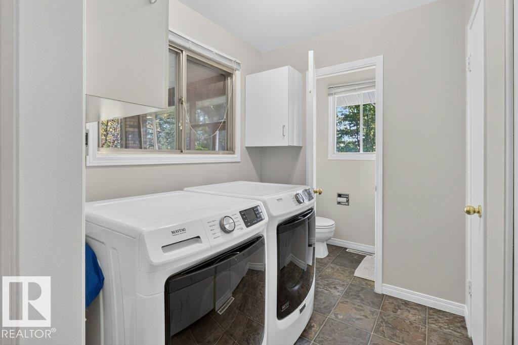 Laundry area featuring tiled flooring, upper white cabinetry, and a window with blinds - #74 22555 Twp Road 530, Rural Strathcona County, AB