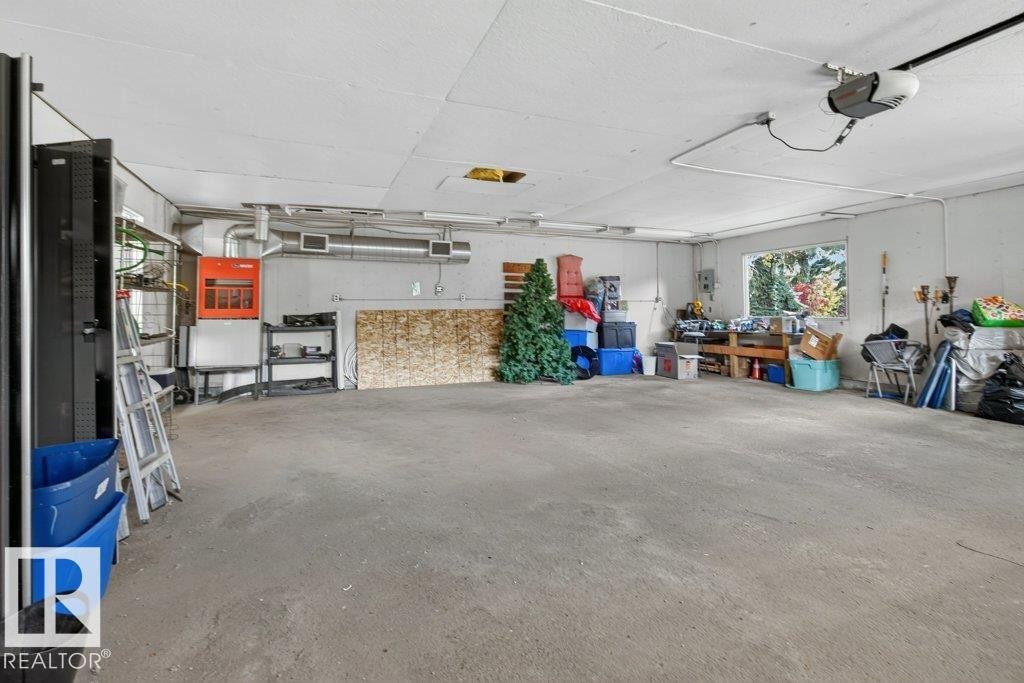 Spacious garage with exposed ductwork, a large window, and a concrete floor - #74 22555 Twp Road 530, Rural Strathcona County, AB