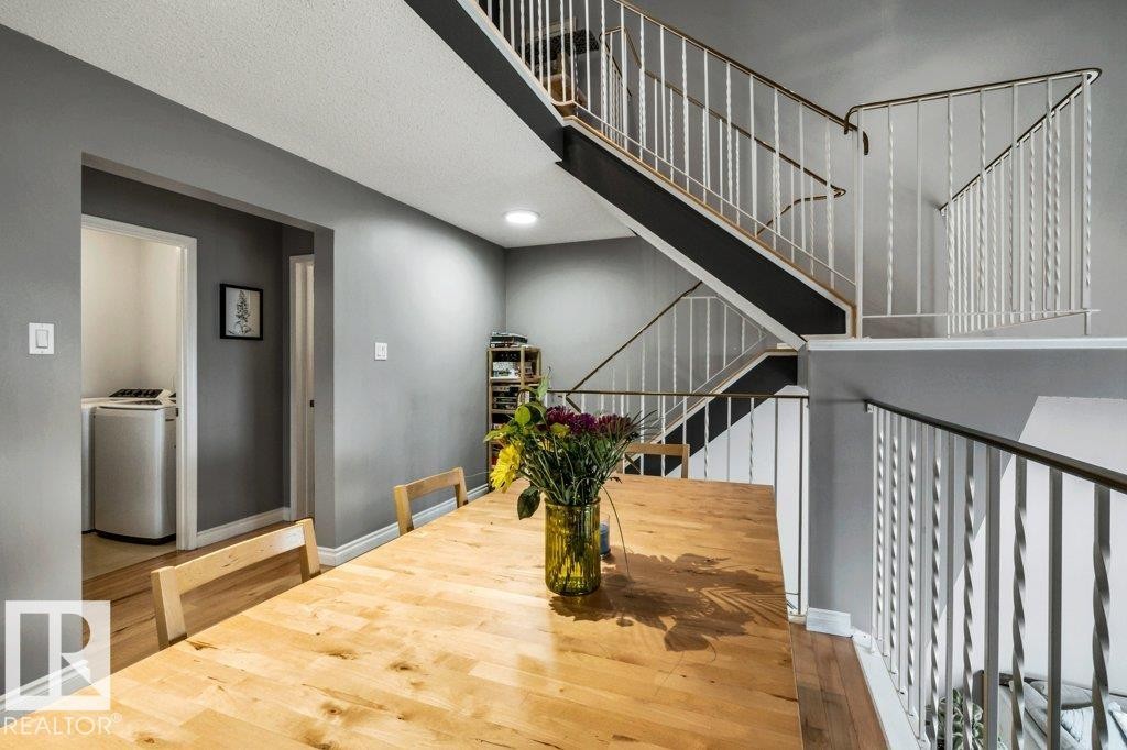 Hardwood flooring throughout, recessed ceiling lighting, and a multi-level staircase with white twisted balusters - #24 3811 85 St Nw, Edmonton, AB