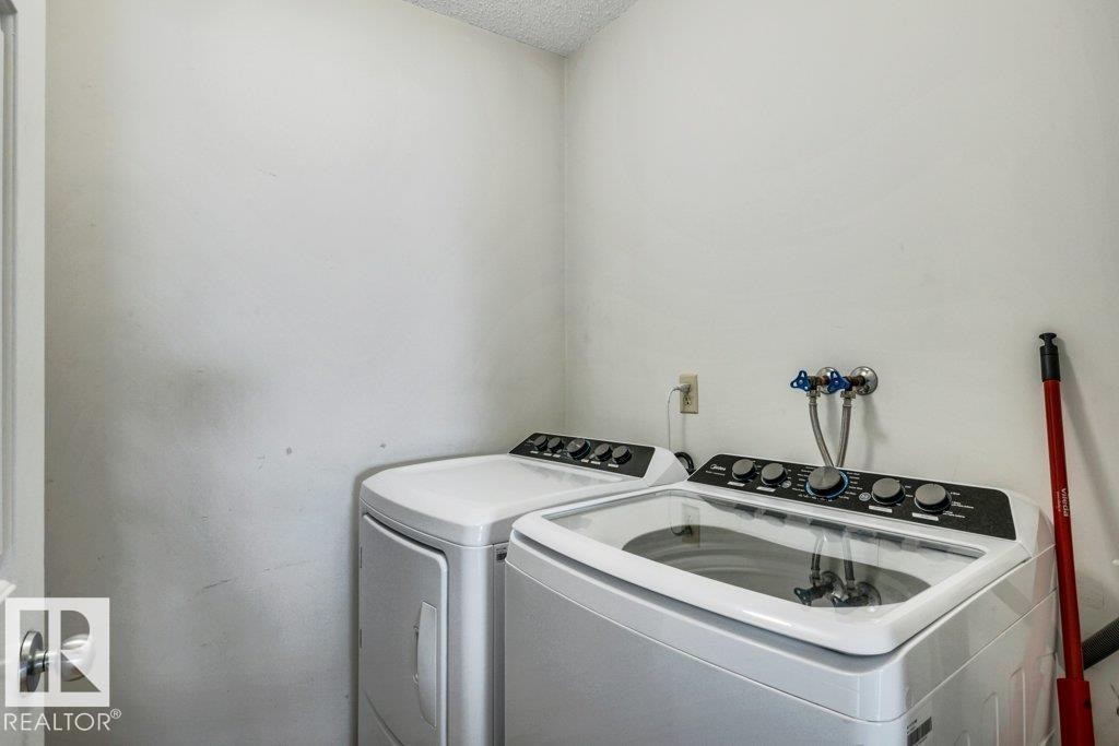 Laundry area featuring white walls and a textured ceiling - #24 3811 85 St Nw, Edmonton, AB