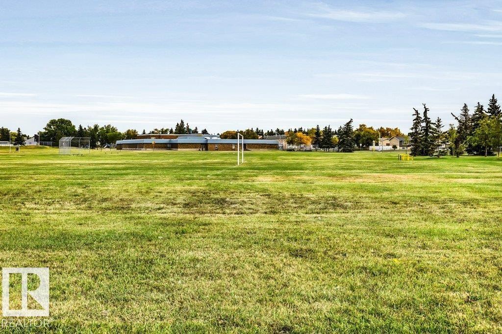 Expansive green space featuring large grassy areas and distant buildings - #24 3811 85 St Nw, Edmonton, AB