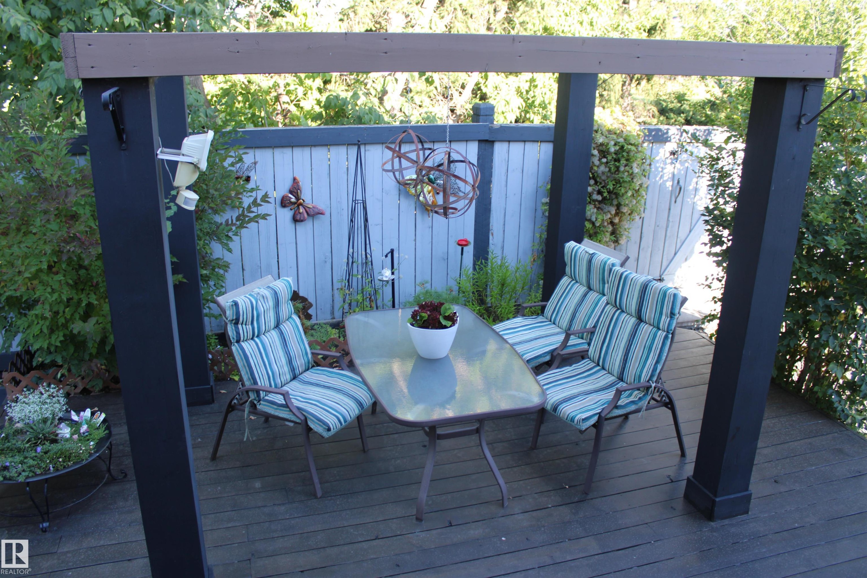 Deck with a wooden pergola featuring dark-painted posts and a natural wood-finish crossbeam - 3815 41 Street Nw, Edmonton, AB