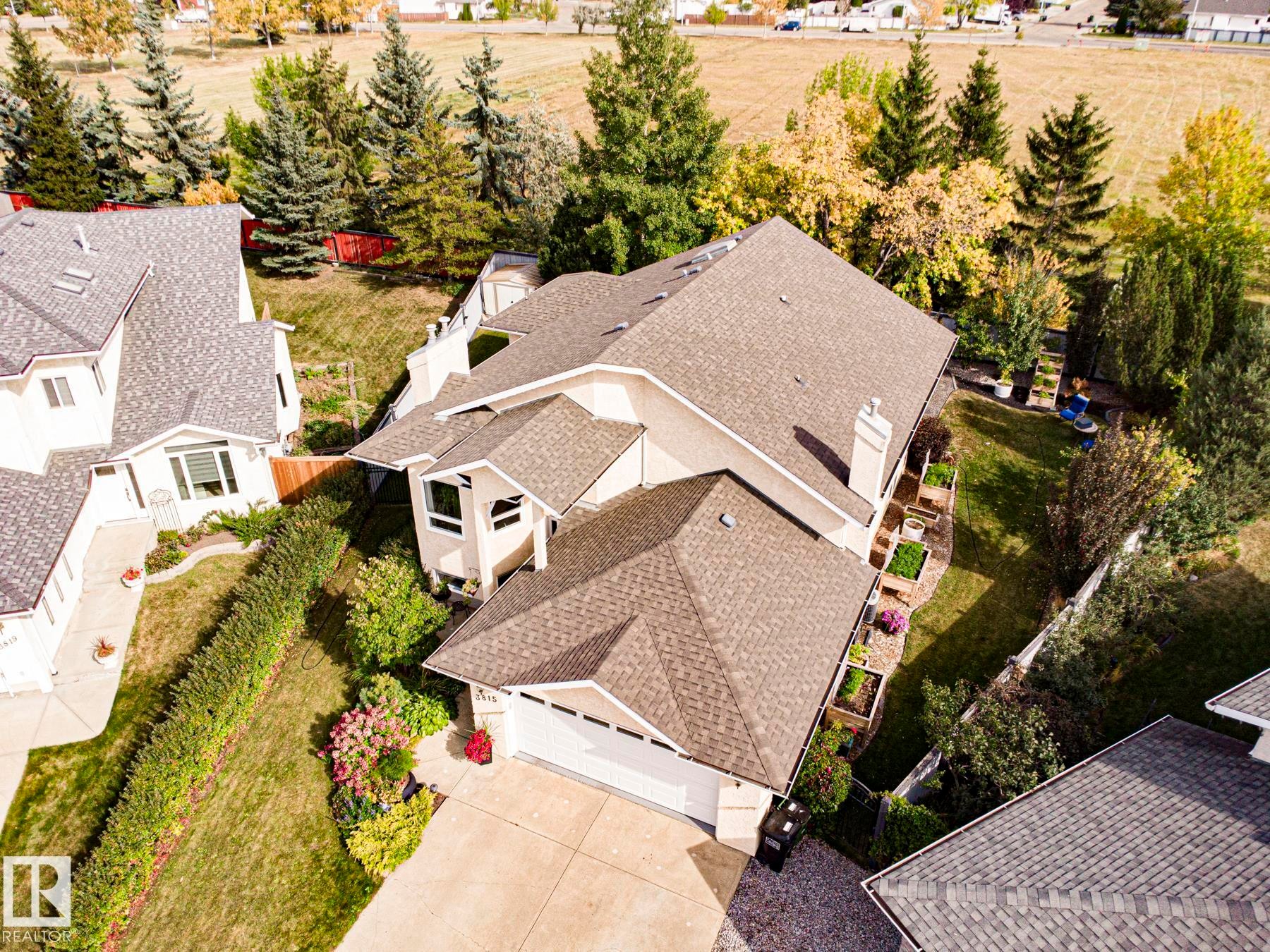 Light-colored stucco exterior with a multi-gabled roof and an attached garage - 3815 41 Street Nw, Edmonton, AB
