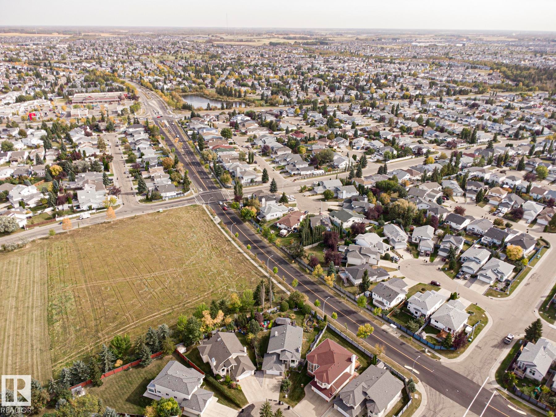 Expansive residential area featuring a central pond, established tree-lined streets, and varied single-family homes - 3815 41 Street Nw, Edmonton, AB