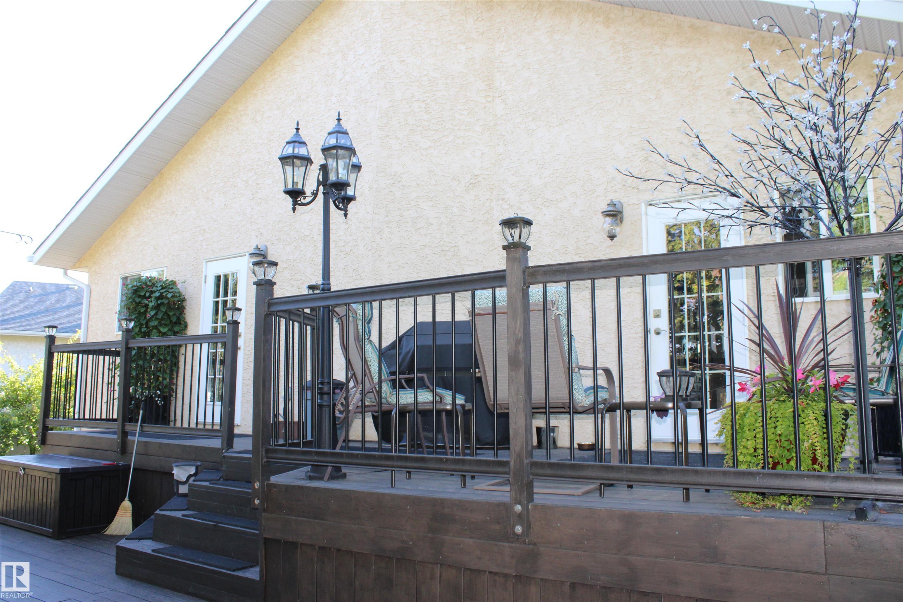 Multi-level deck with dark wood-finish railing, post-cap lighting, and a prominent decorative lamppost - 3815 41 Street Nw, Edmonton, AB