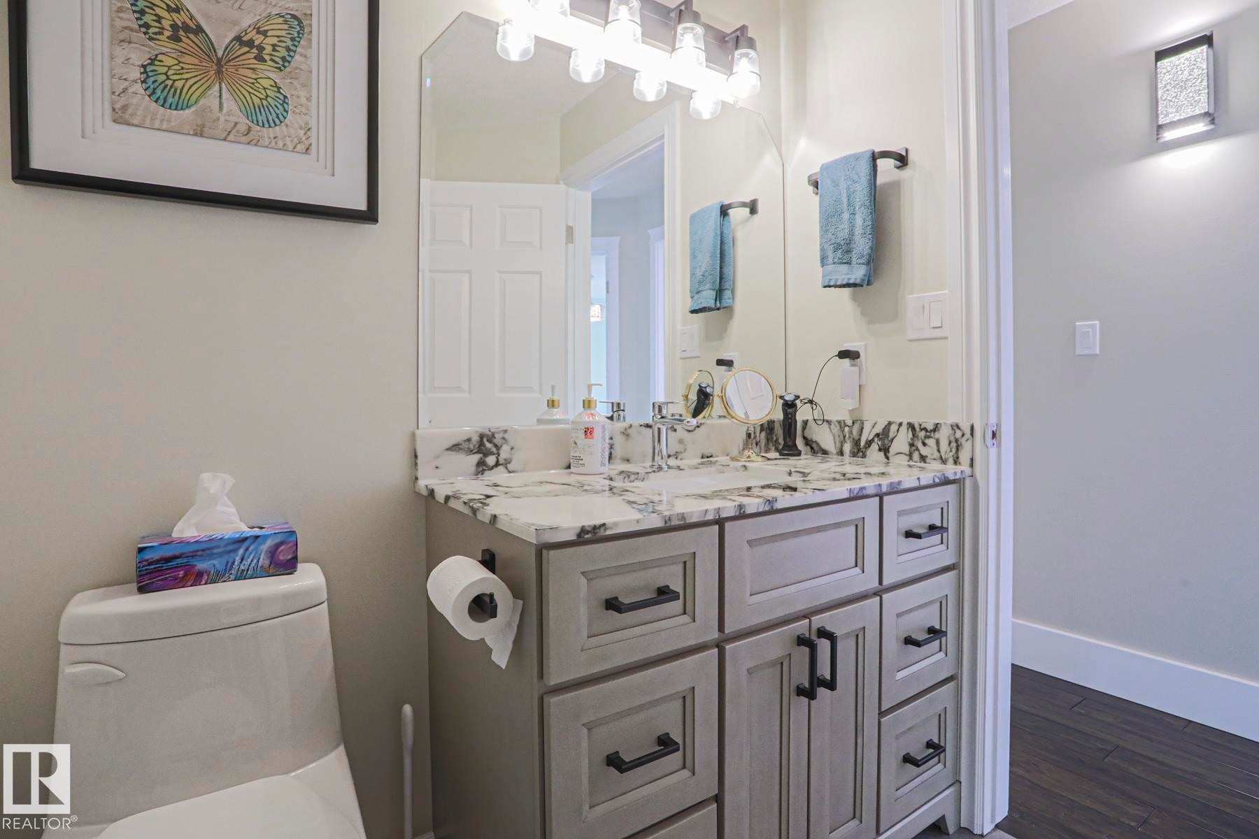 Vanity with a light gray finish, black hardware, and a marbled countertop - 3815 41 Street Nw, Edmonton, AB