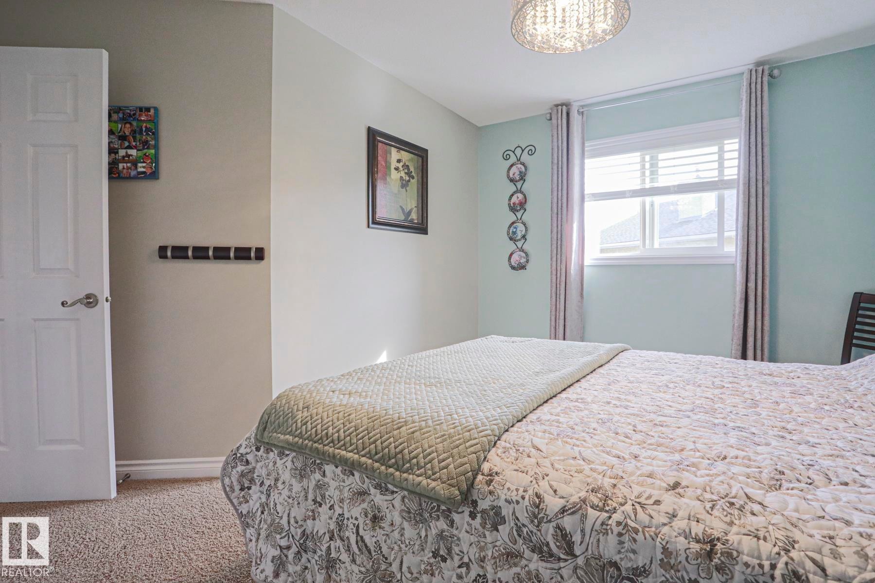 Wall-to-wall carpeting with a white paneled door and window with blinds - 3815 41 Street Nw, Edmonton, AB