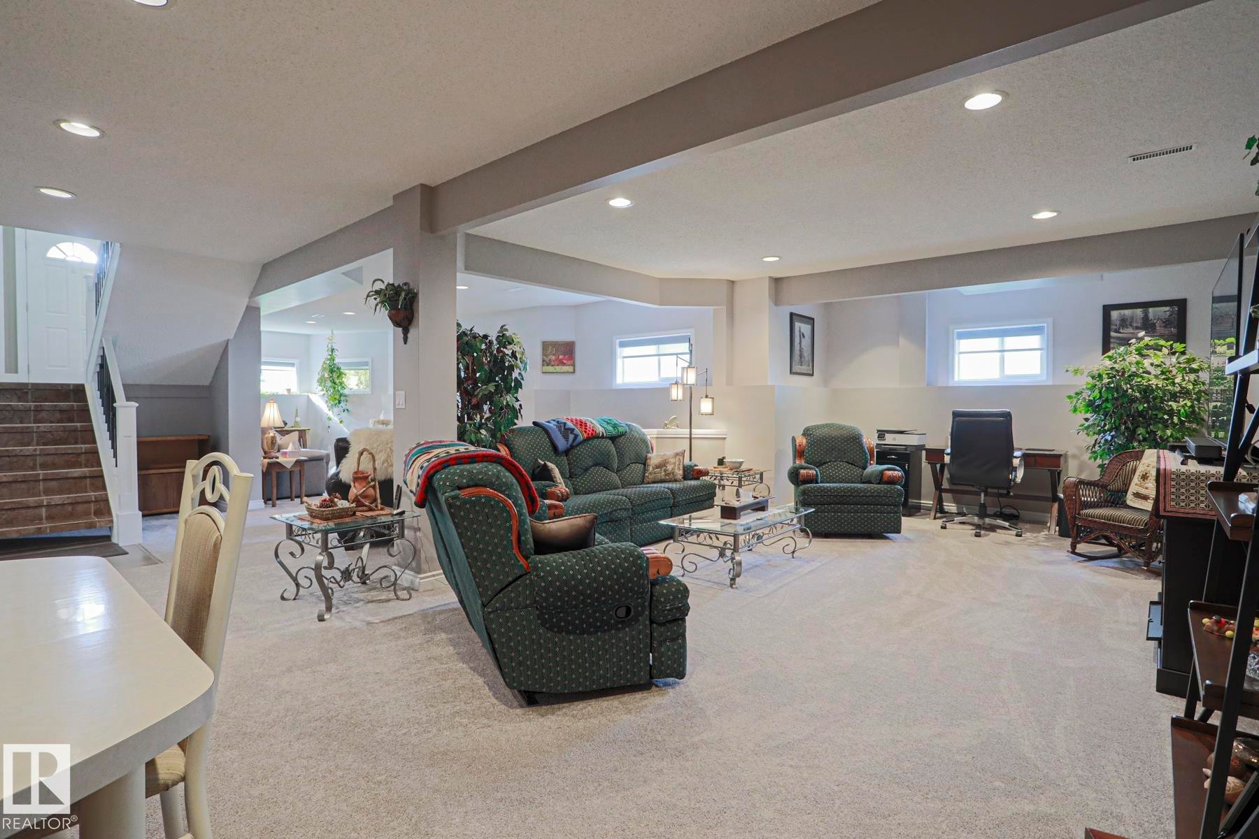 Spacious lower level featuring recessed lighting, carpet flooring, a visible staircase, and multiple windows - 3815 41 Street Nw, Edmonton, AB