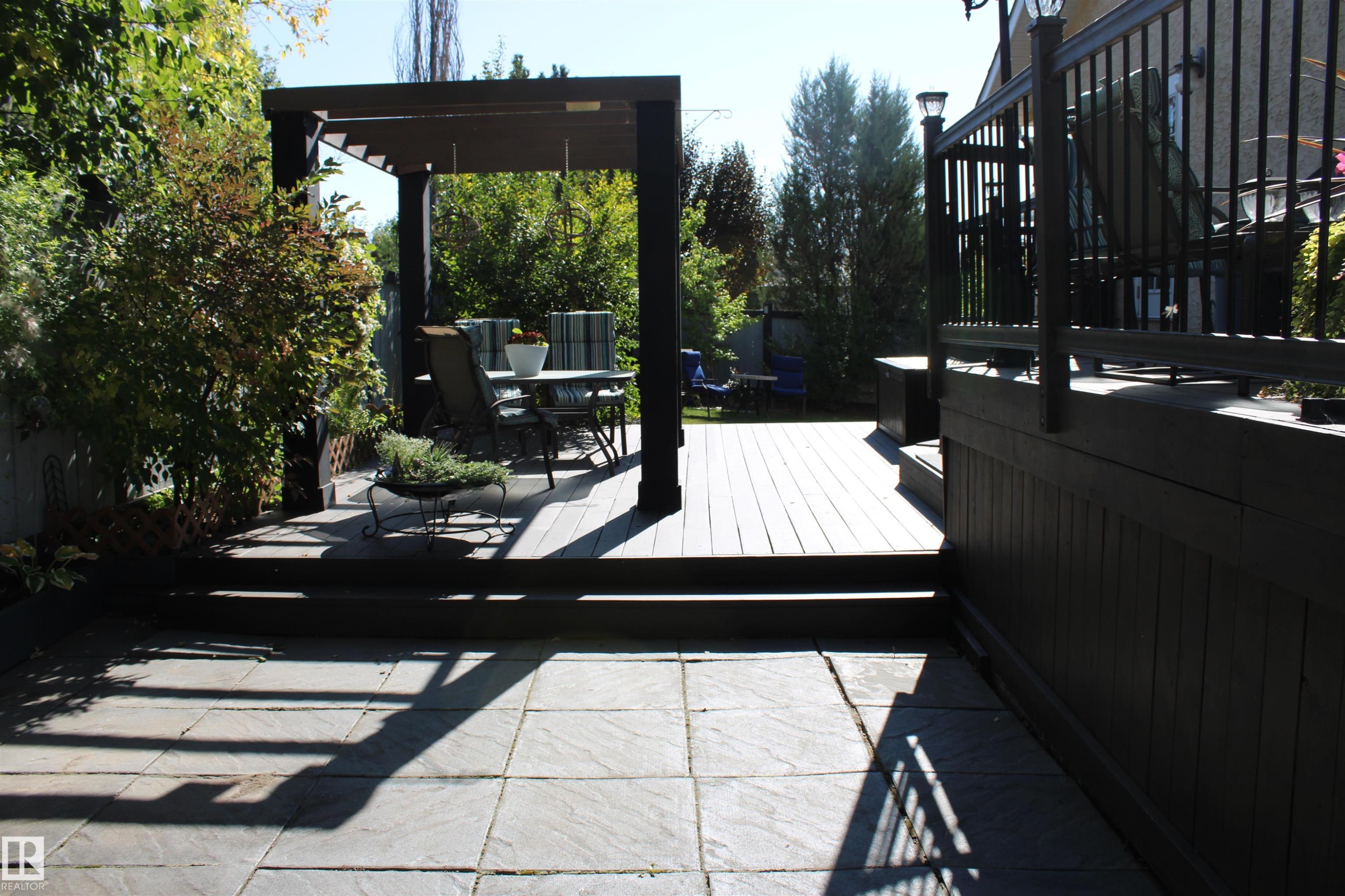 Expansive paver patio with a multi-level wood deck, pergola, and black metal railings - 3815 41 Street Nw, Edmonton, AB