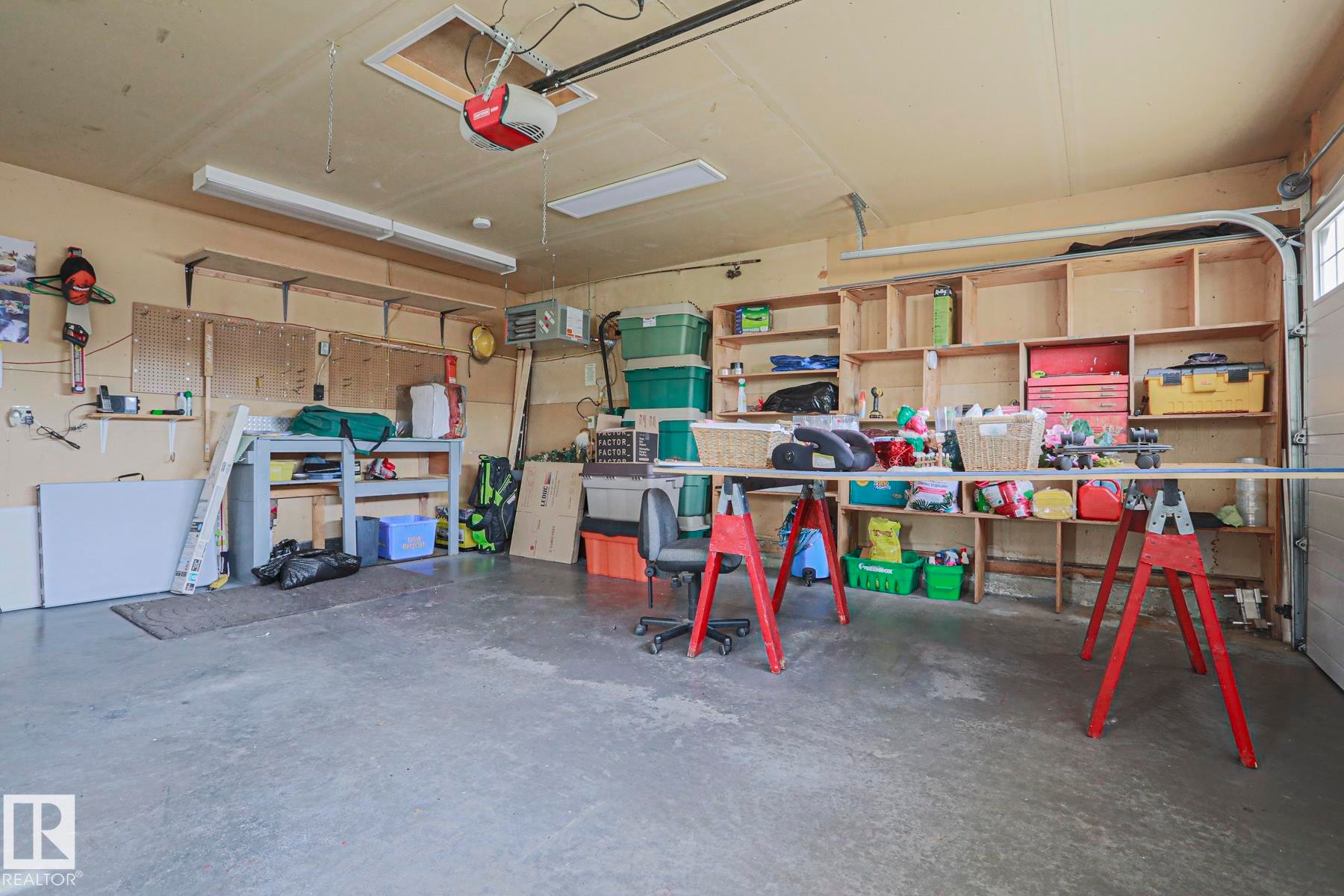 Heated Garage with concrete flooring, built-in shelving, overhead lighting, and an automatic garage door opener - 3815 41 Street Nw, Edmonton, AB