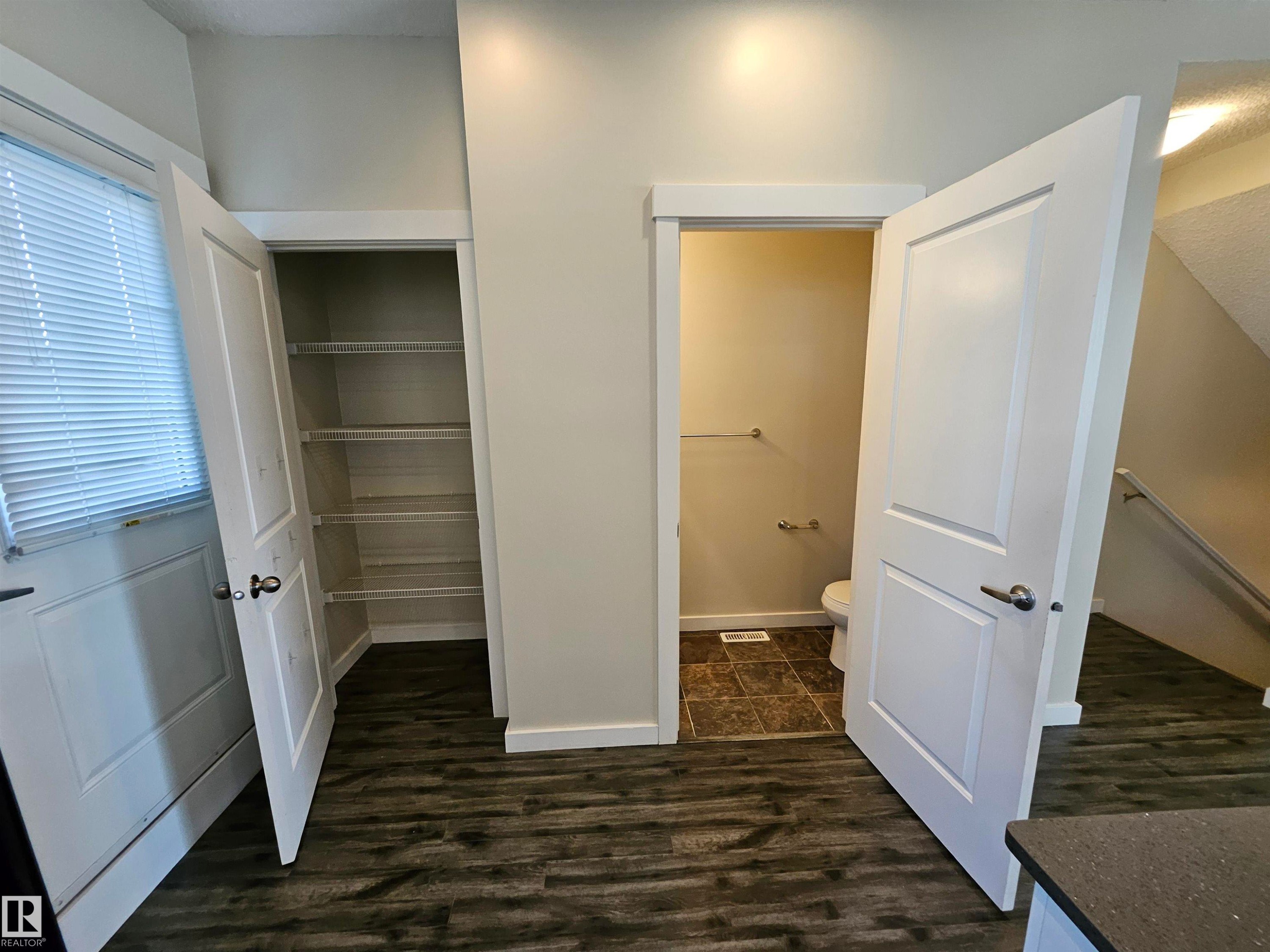 Wood-finish flooring throughout, pantry with built-in shelving, white paneled interior doors, and a bathroom with tile flooring - #69 903 Crystallina Nera Wy Nw, Edmonton, AB