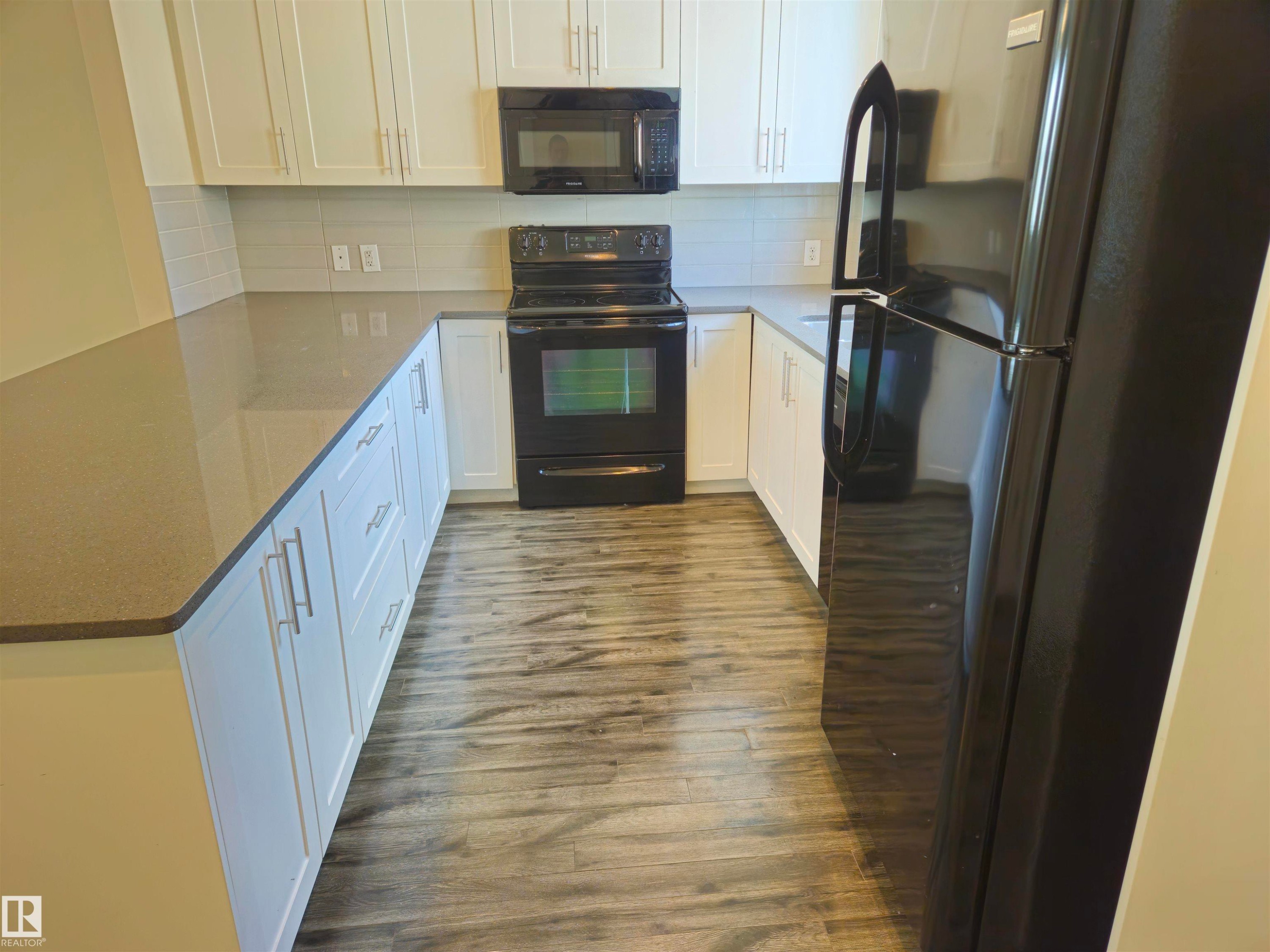 U-shaped kitchen with white cabinetry and dark countertops - #69 903 Crystallina Nera Wy Nw, Edmonton, AB