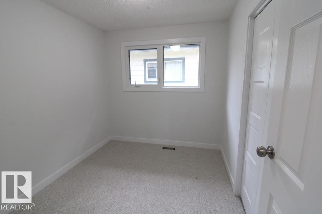 Light-colored carpeting, white walls, and a window with white trim - 44 Arlington Drive, St. Albert, AB