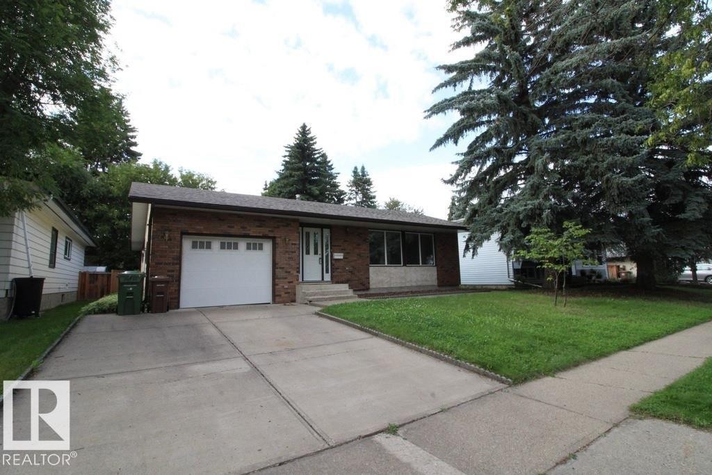 Brick exterior with a single-car garage and concrete driveway - 44 Arlington Drive, St. Albert, AB