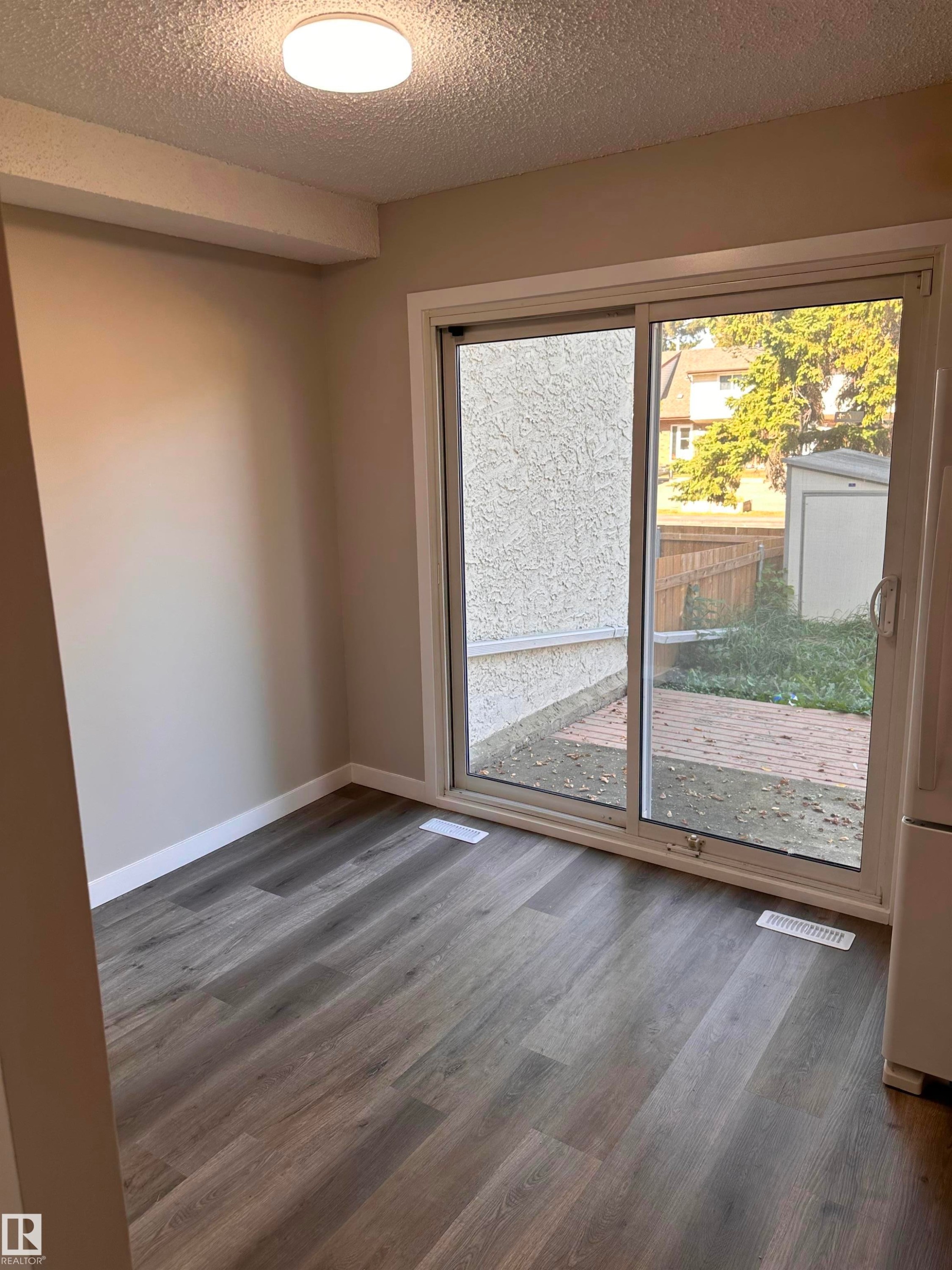 Modern wood-finish flooring with a large window, providing natural light - 9G Clareview Village Nw, Edmonton, AB