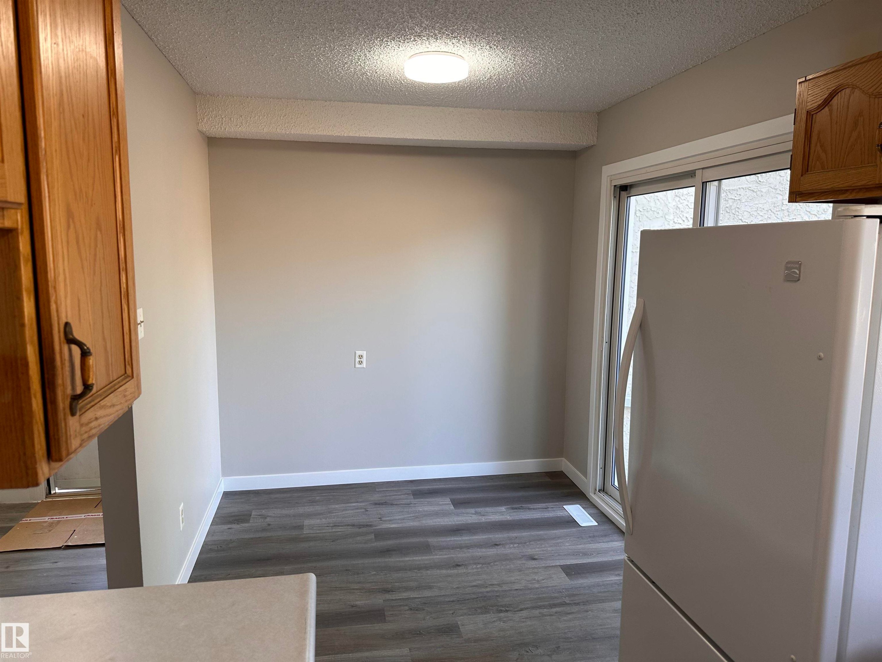 Wood-finish flooring, light-toned walls, and a sliding glass door - 9G Clareview Village Nw, Edmonton, AB