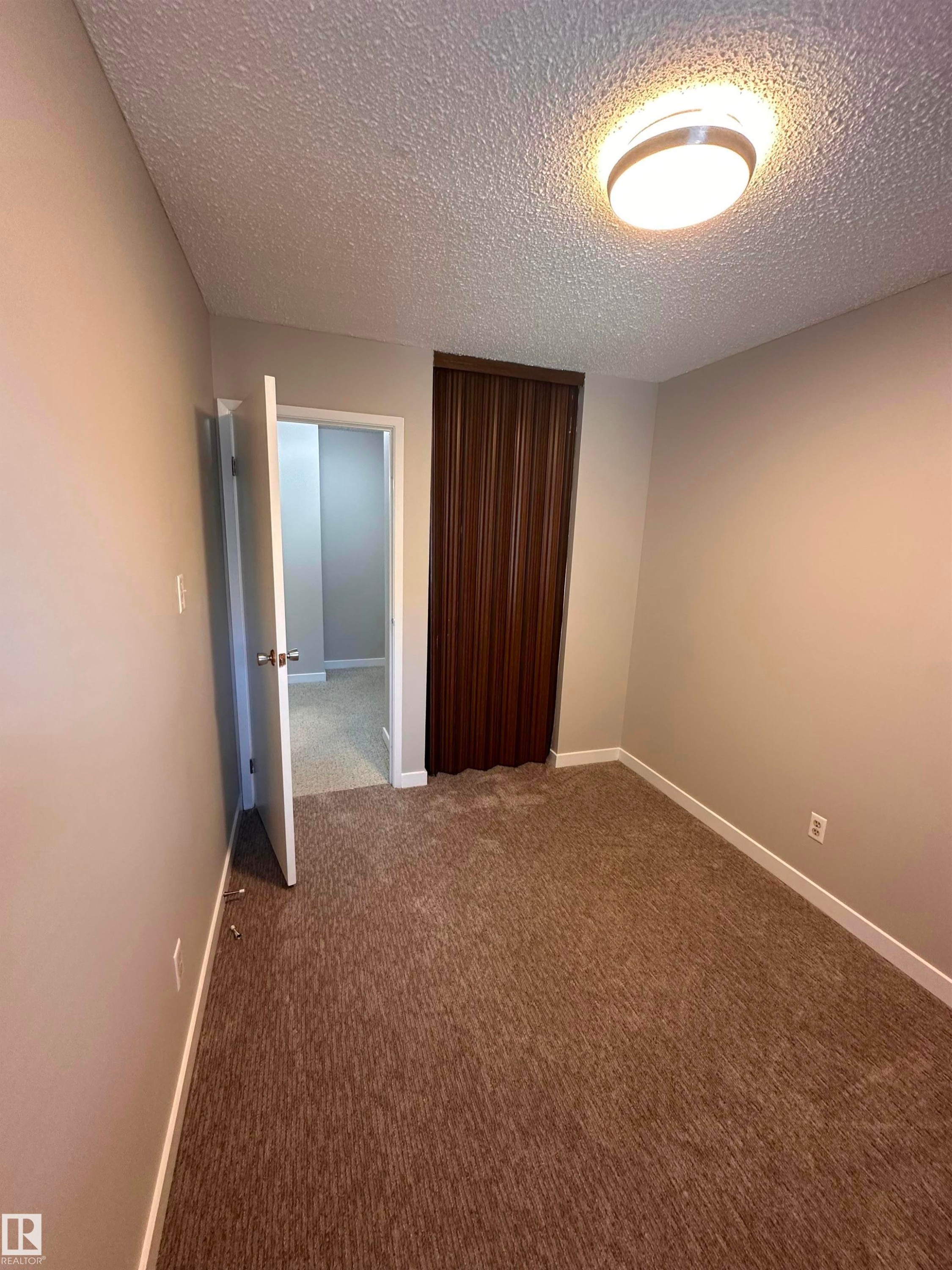 Textured wall with a circular wall-mounted light fixture - 9G Clareview Village Nw, Edmonton, AB