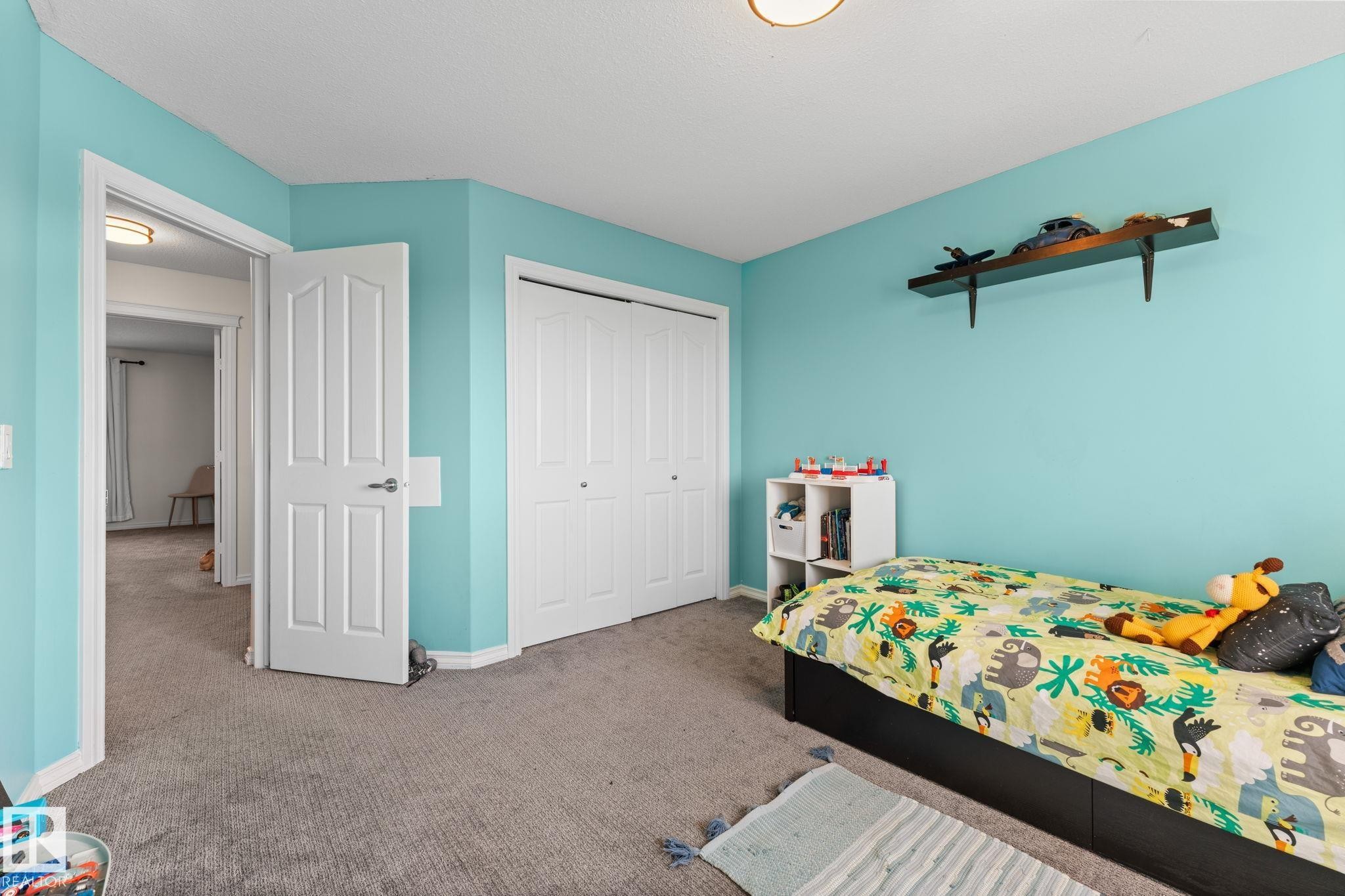Carpeted flooring, white trim, and a white bi-fold closet door - #5 4900 62 St, Beaumont, AB