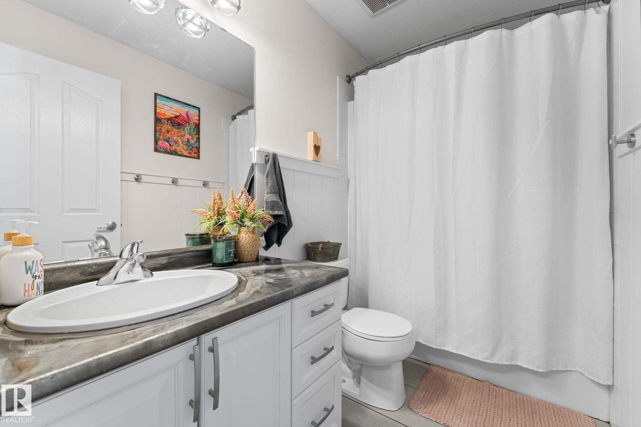 Vanity with integrated sink, chrome faucet, and dark-toned countertop - #5 4900 62 St, Beaumont, AB
