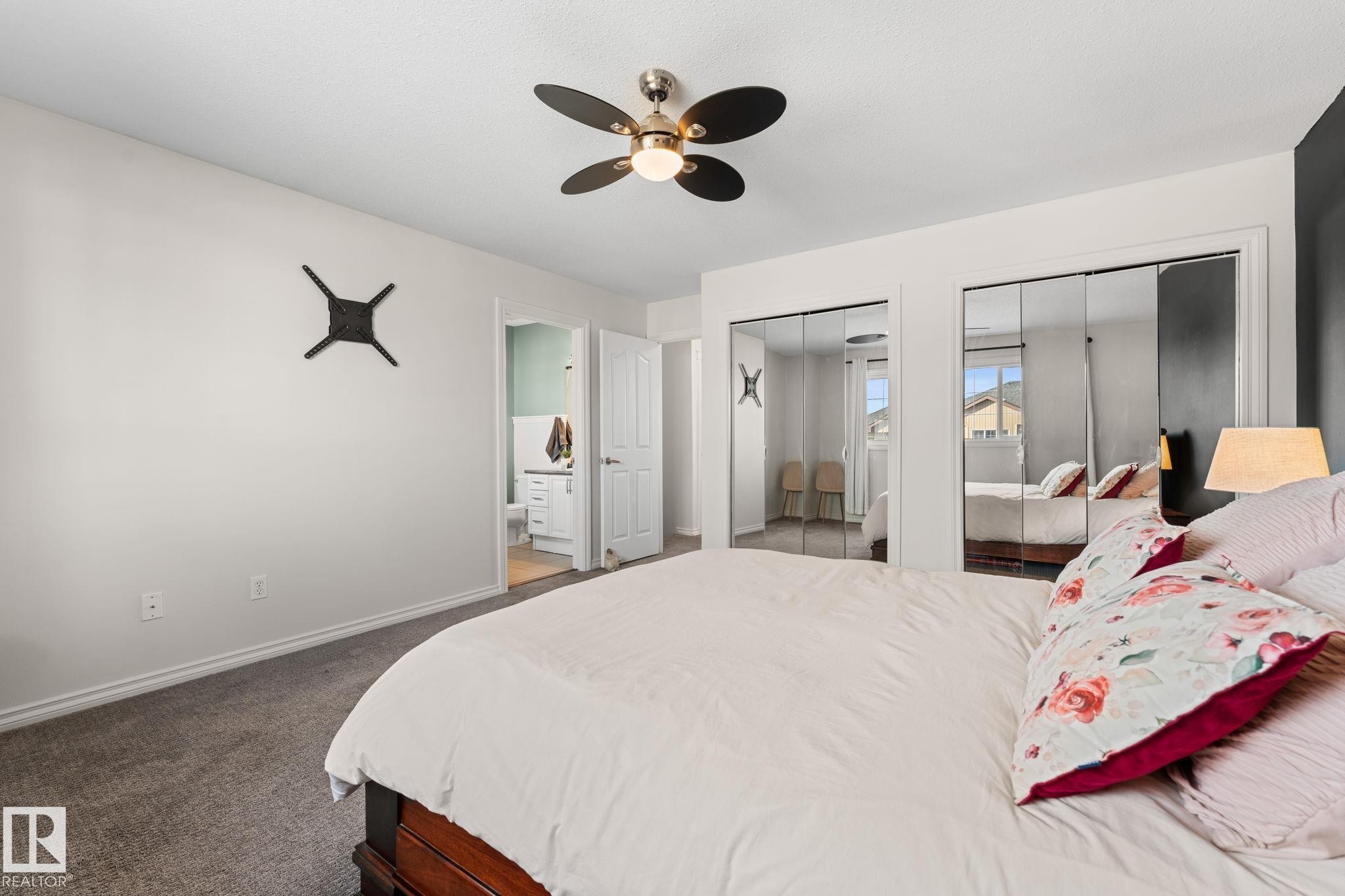 Recessed mirrored closet doors, a contemporary ceiling fan, and carpeted flooring - #5 4900 62 St, Beaumont, AB