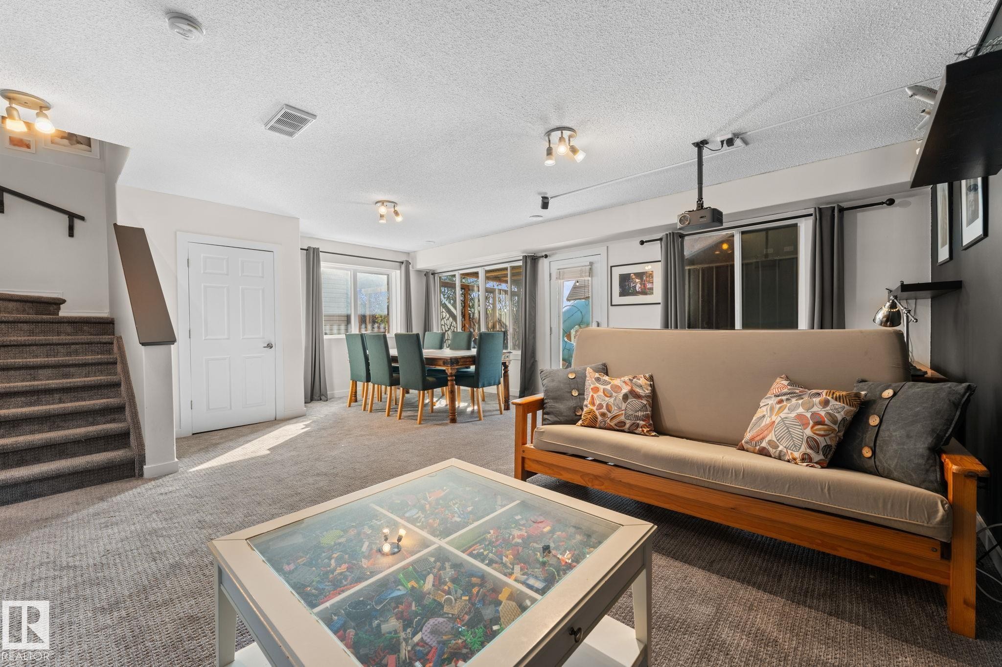 Carpeted lower level with recessed lighting, an interior staircase, and sliding glass doors - #5 4900 62 St, Beaumont, AB