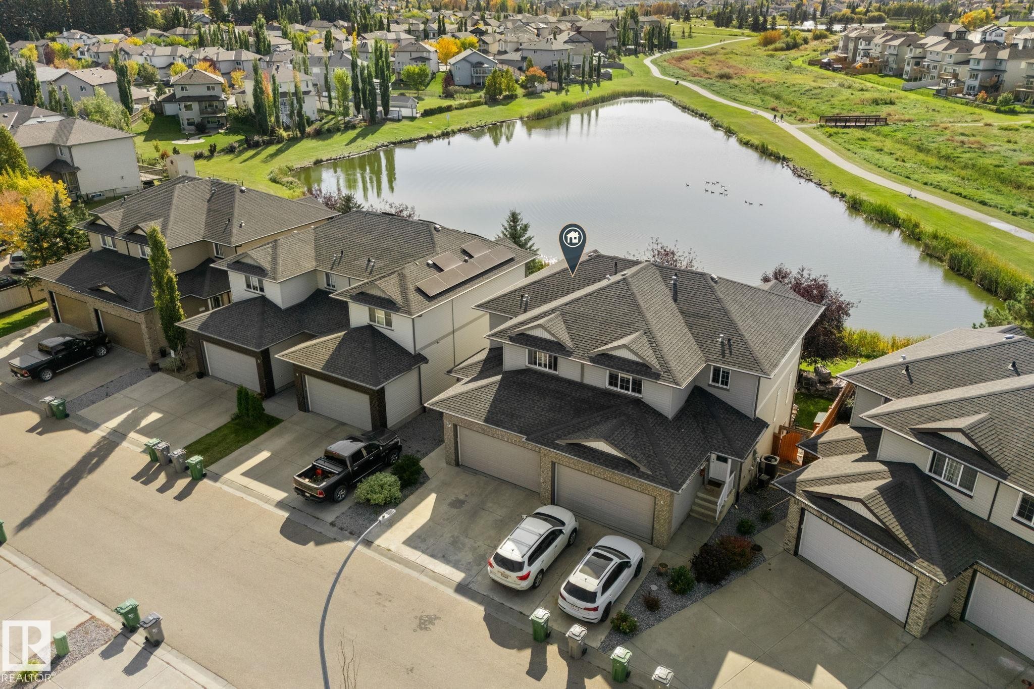 Property with a multi-car driveway, attached garage, and a sloped roof - #5 4900 62 St, Beaumont, AB