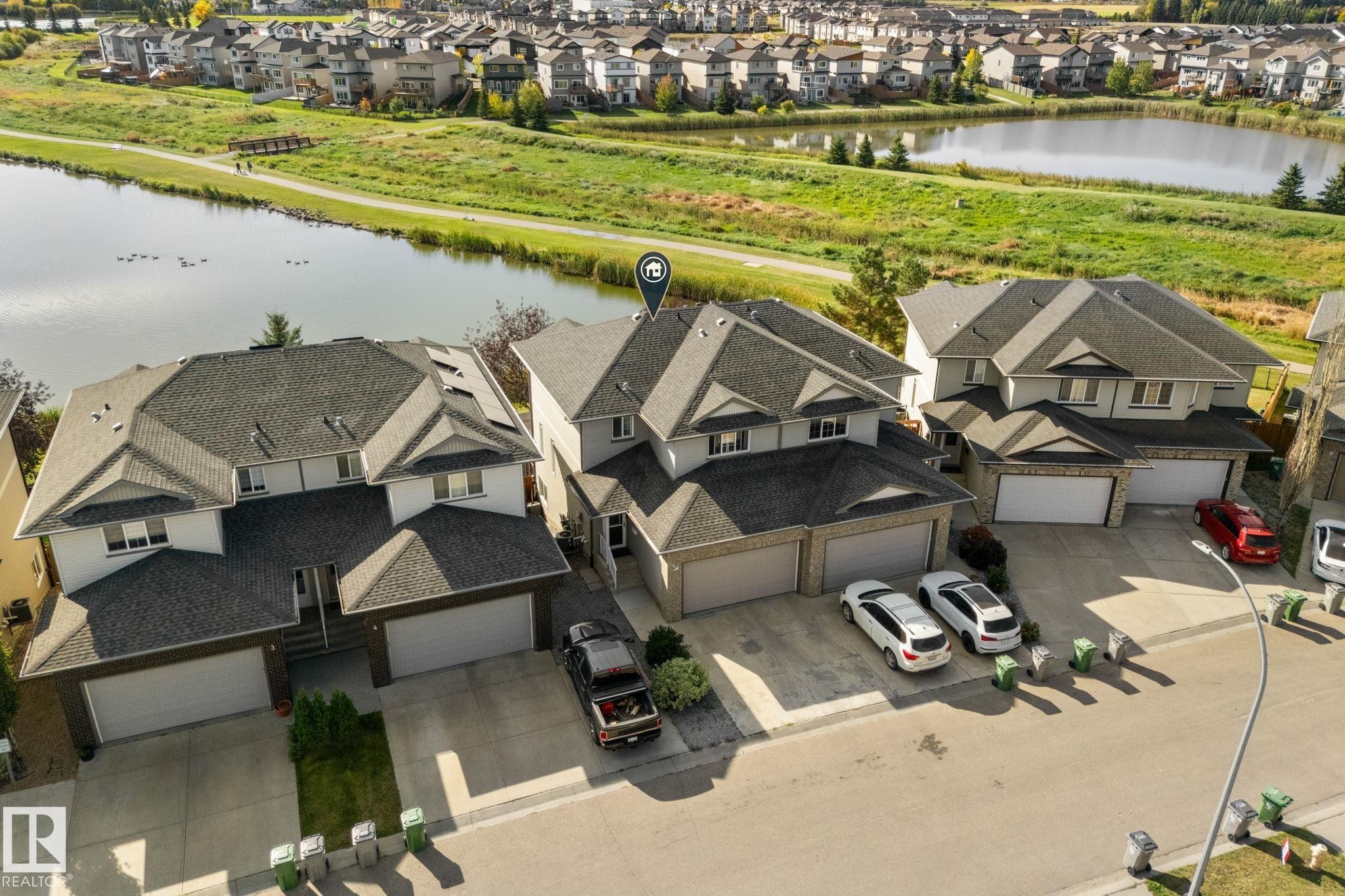 Detached property with a dual-pitched roof, attached two-car garage, and a paved driveway - #5 4900 62 St, Beaumont, AB