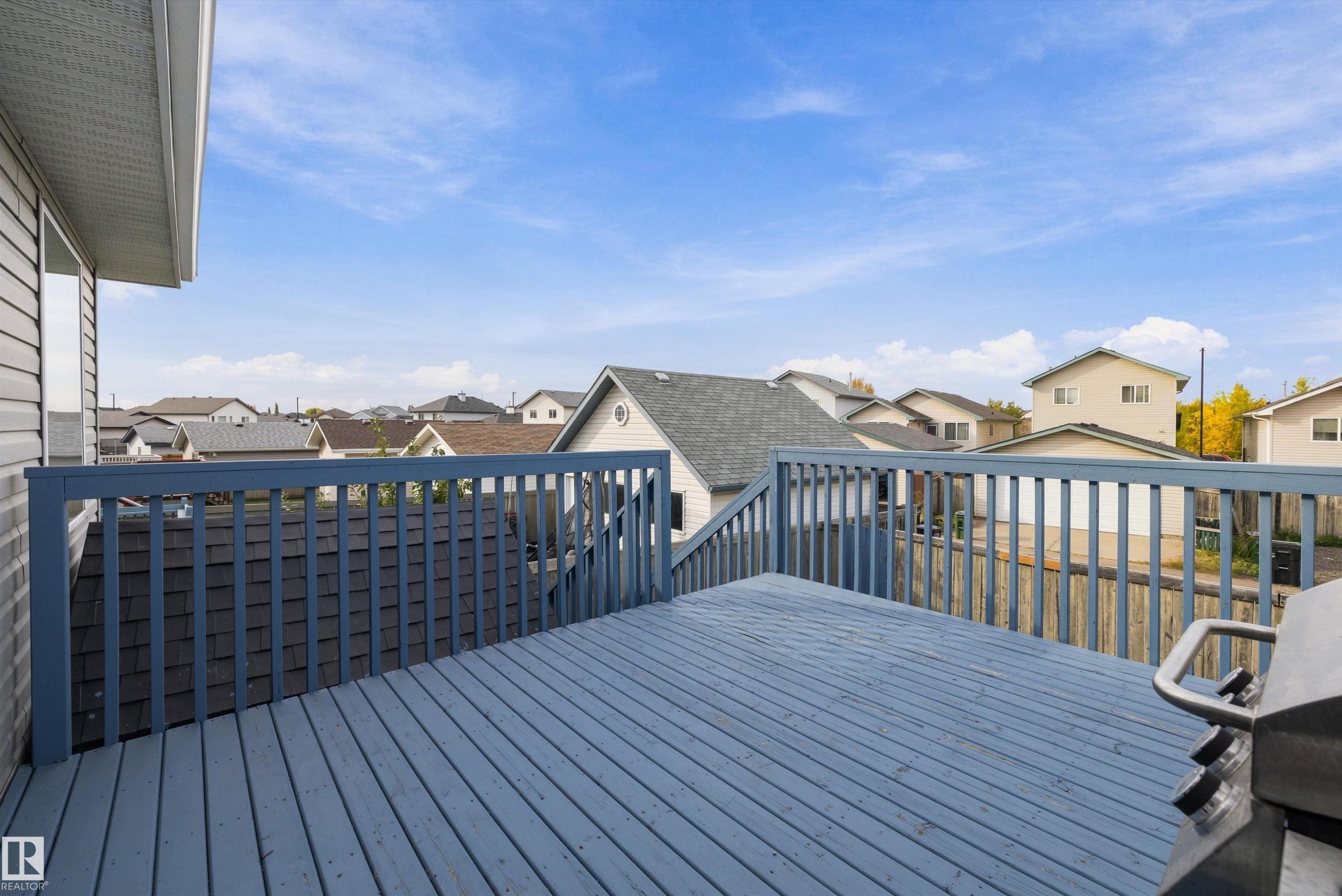 Elevated outdoor deck with painted wood railing and decking - 3114 32 Avenue Nw, Edmonton, AB