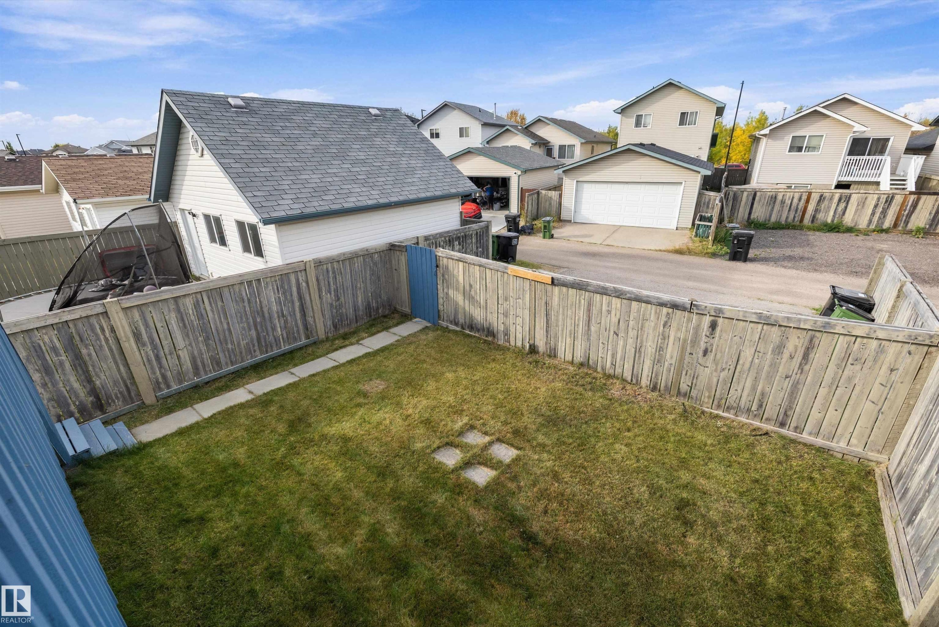 Fenced backyard with a grassy area and stone stepping path - 3114 32 Avenue Nw, Edmonton, AB