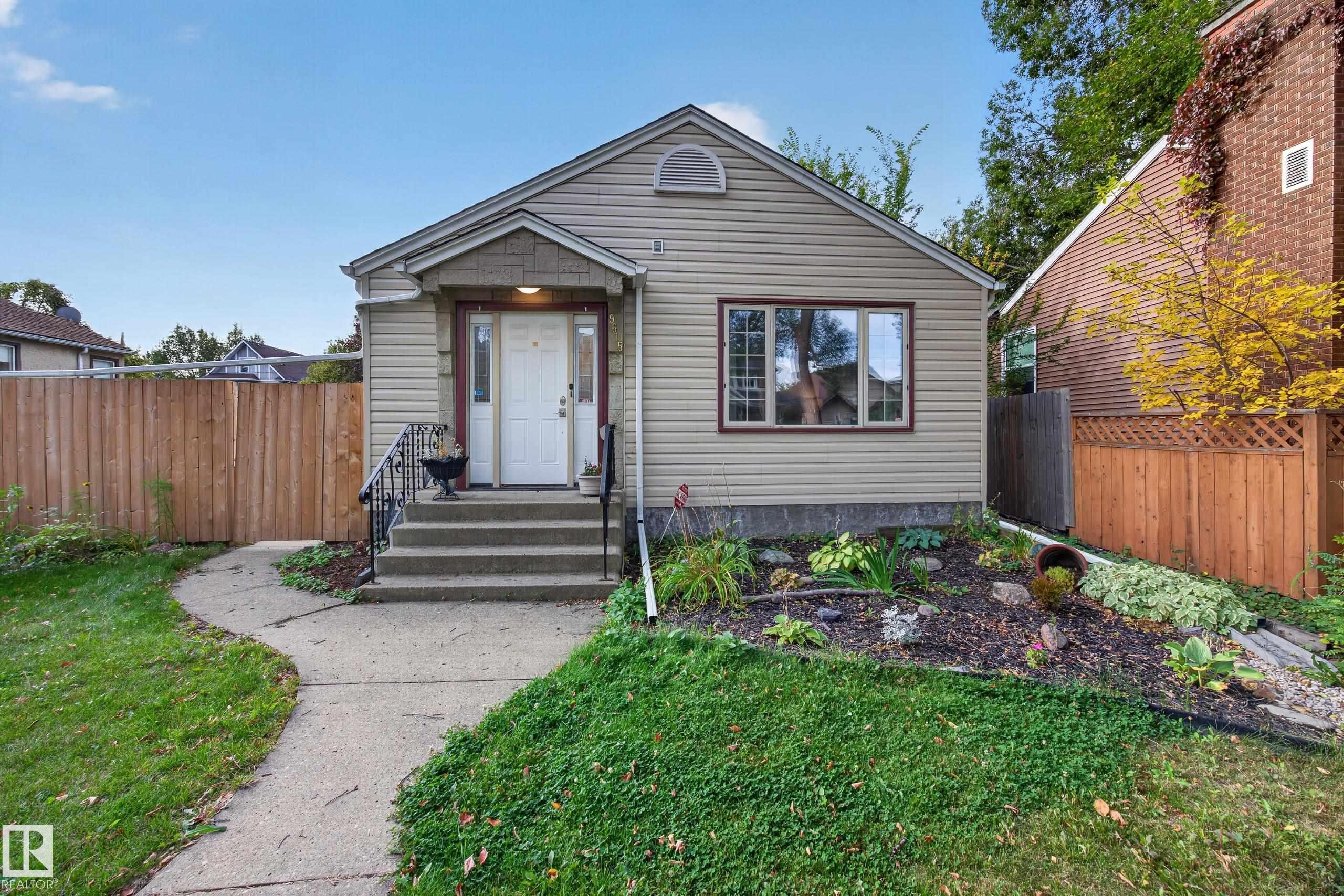 Siding exterior featuring a front entry with concrete steps and wrought iron railings - 9615 75 Avenue Nw, Edmonton, AB