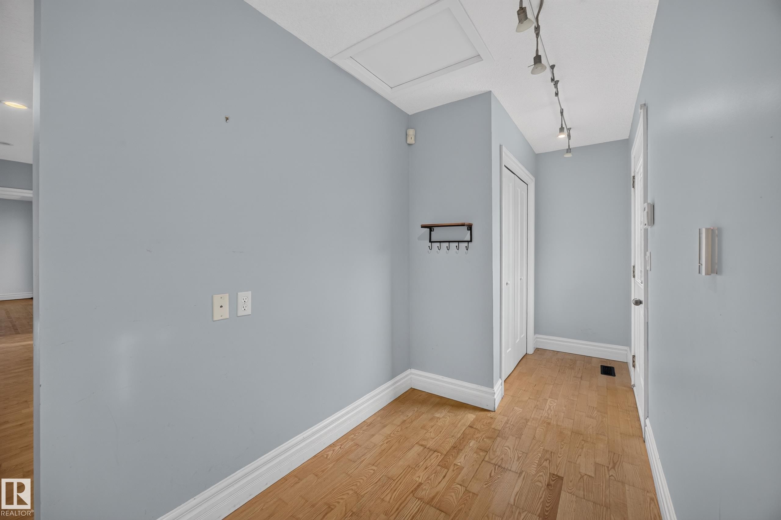Wood-finish flooring, white trim, track lighting, and a built-in closet - 9615 75 Avenue Nw, Edmonton, AB