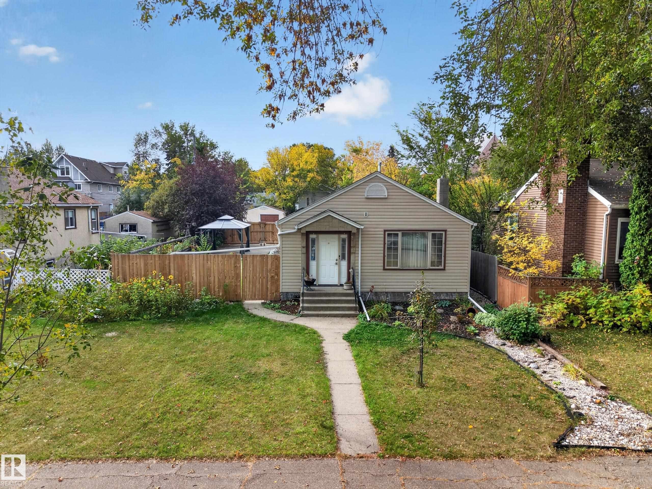 Single-story residence featuring light-colored siding, a front entry with steps, and a concrete pathway - 9615 75 Avenue Nw, Edmonton, AB