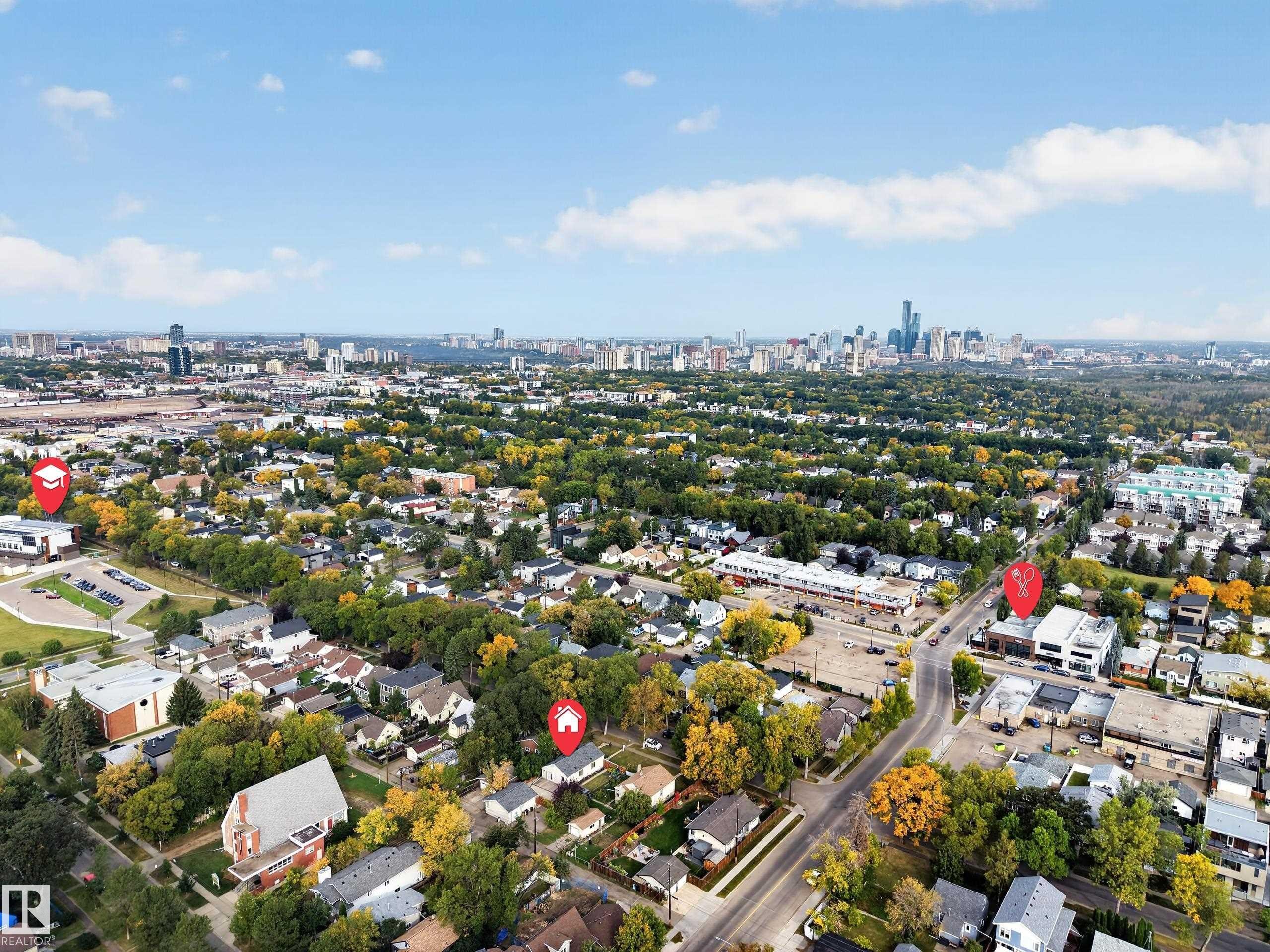 Aerial perspective showcasing an urban skyline in the background, residential areas with mature trees, commercial buildings, and paved roadways - 9615 75 Avenue Nw, Edmonton, AB