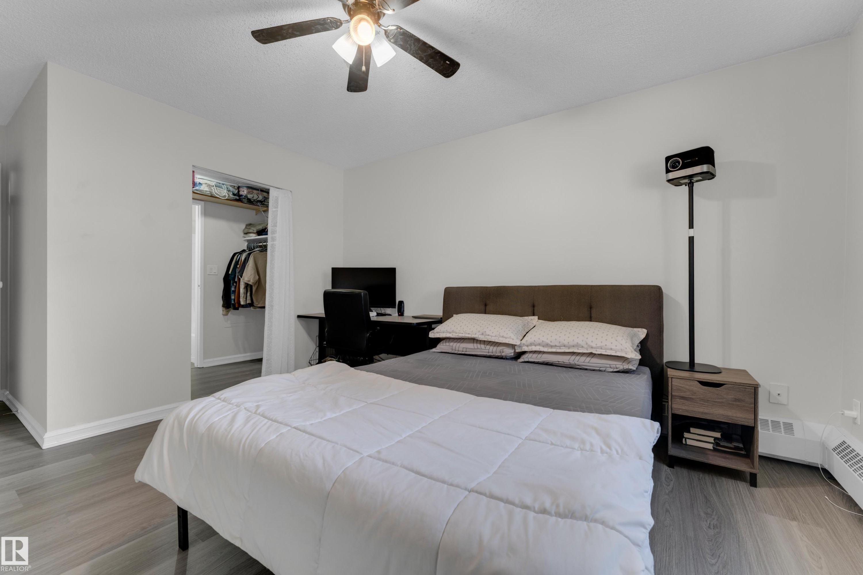 Recessed closet area, ceiling fan with integrated lighting, and wood-finish flooring - #113 2508 50 St Nw, Edmonton, AB