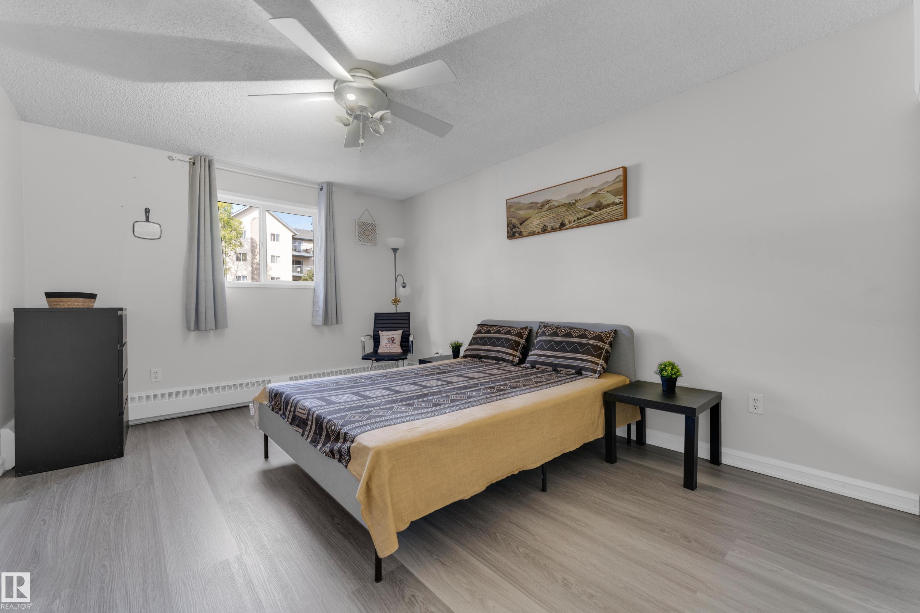 Recessed lighting, ceiling fan, wood-finish flooring, white walls, and a window with natural light - #113 2508 50 St Nw, Edmonton, AB