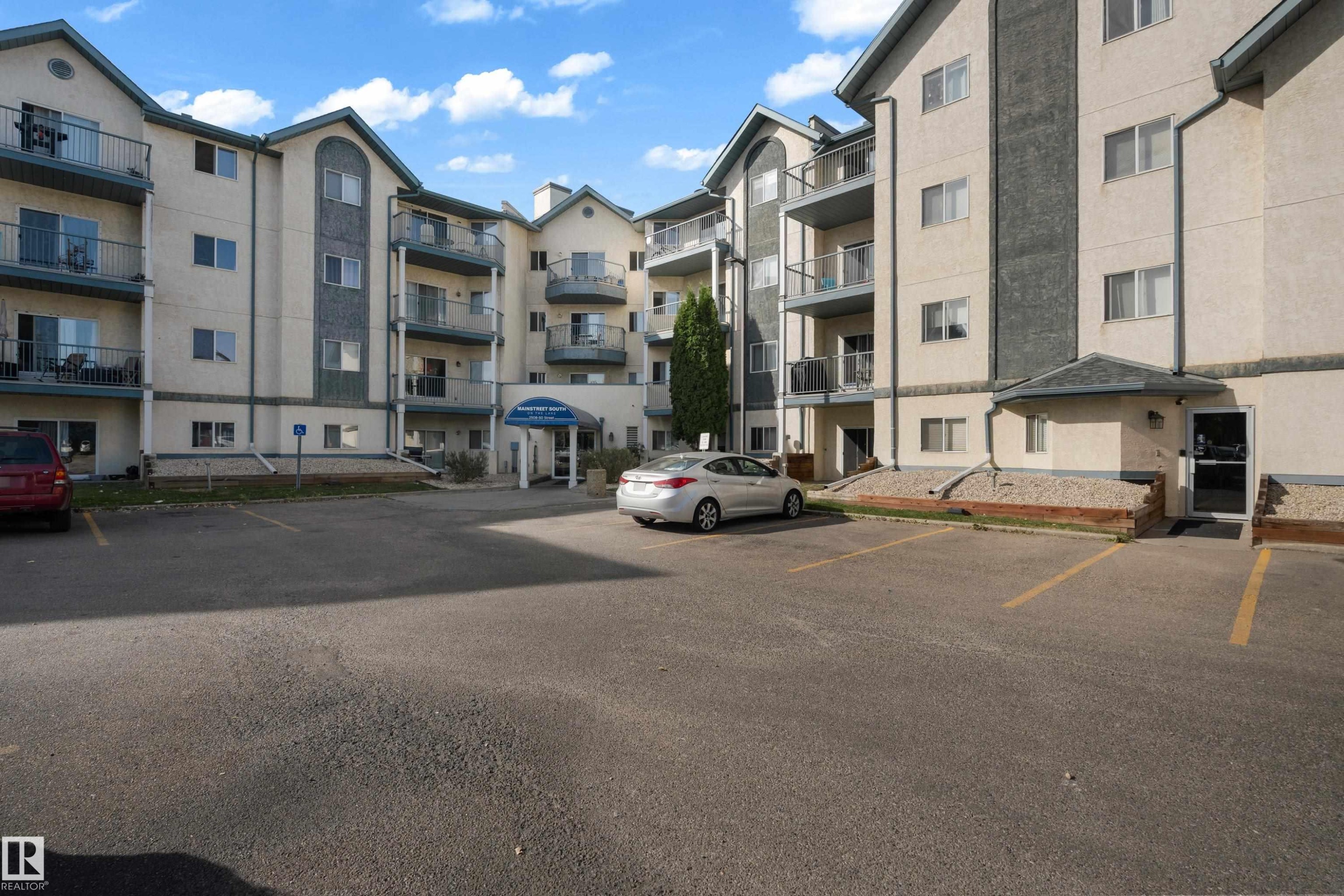 Multi-story building featuring stucco and stone-look exterior accents - #113 2508 50 St Nw, Edmonton, AB