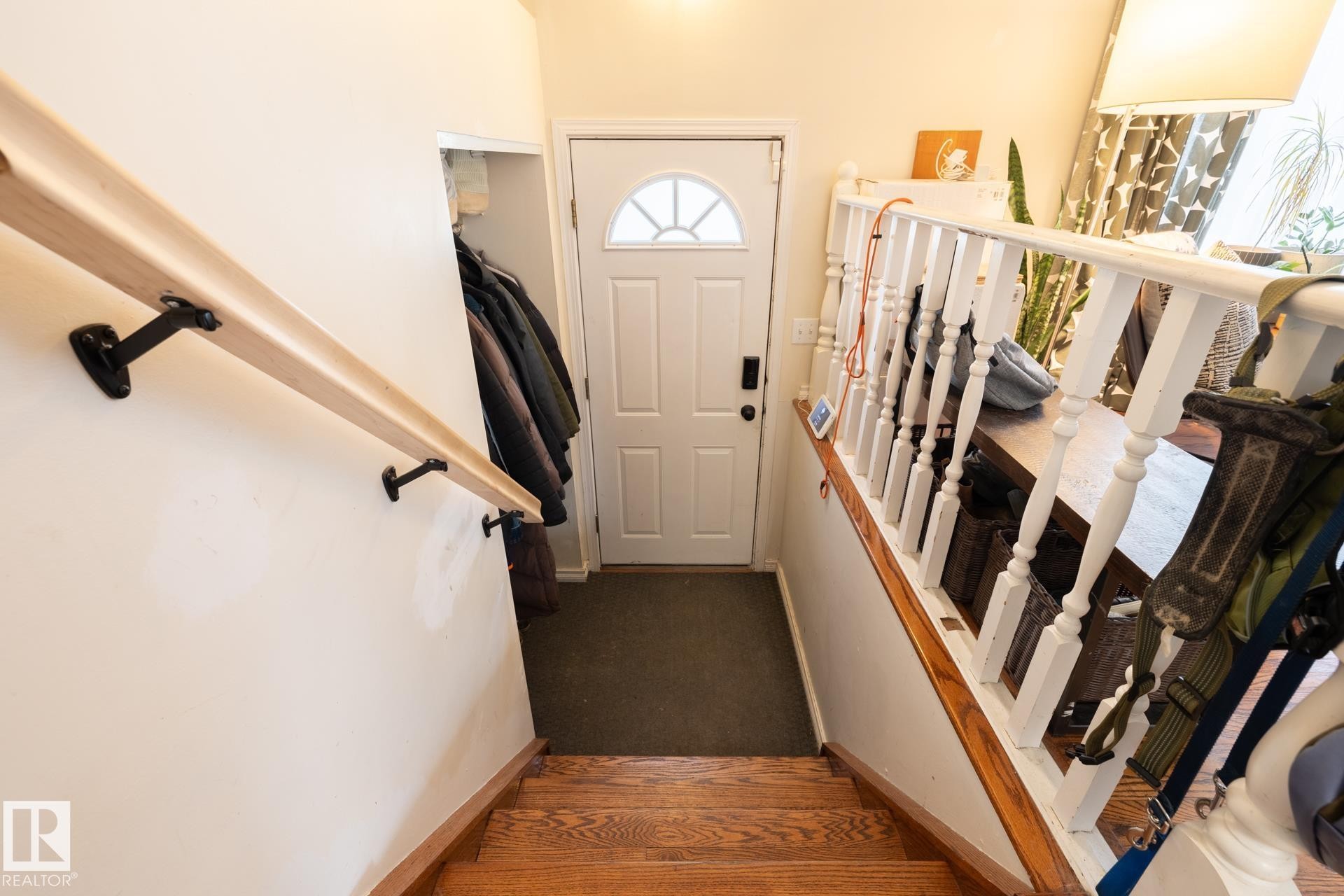 Wood-finish stairs with a natural wood-finish handrail and painted white balusters - 10972 157 Street Nw, Edmonton, AB