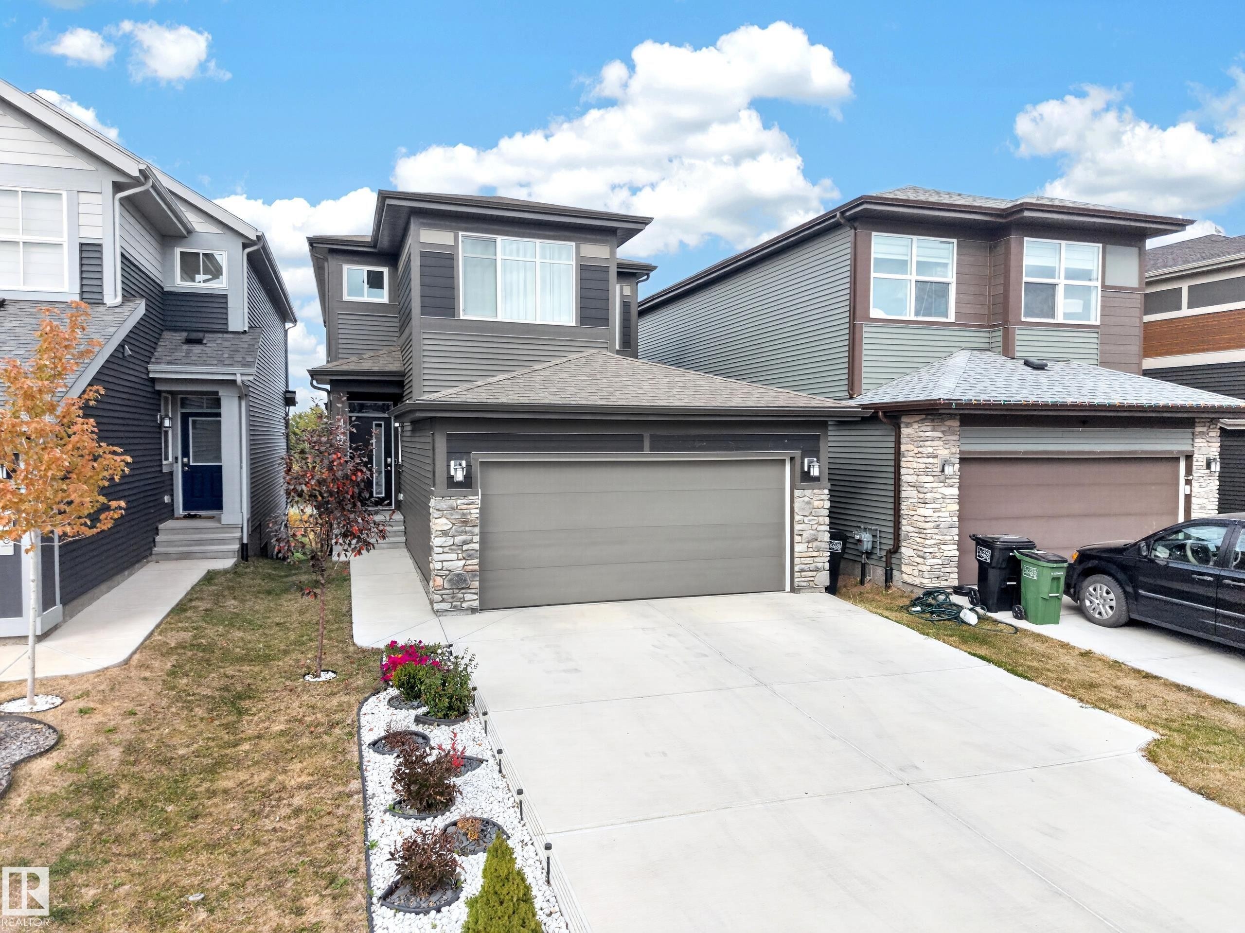Contemporary exterior with multi-level siding, stone veneer accents, and an attached two-car garage - 4104 3 Avenue Sw, Edmonton, AB