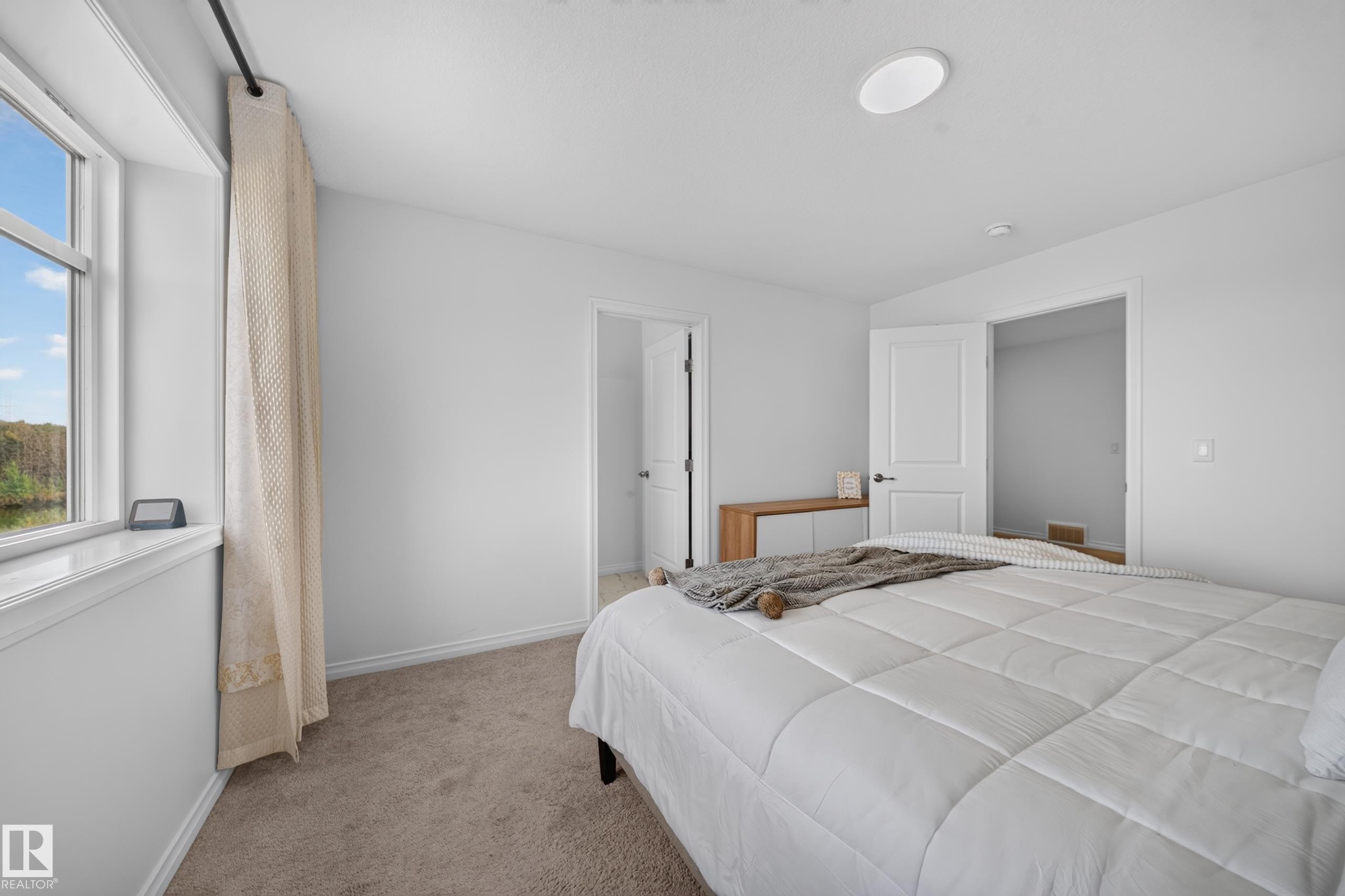 Recessed ceiling lighting, durable carpeting, crisp white walls, and a window with a water feature - 4104 3 Avenue Sw, Edmonton, AB
