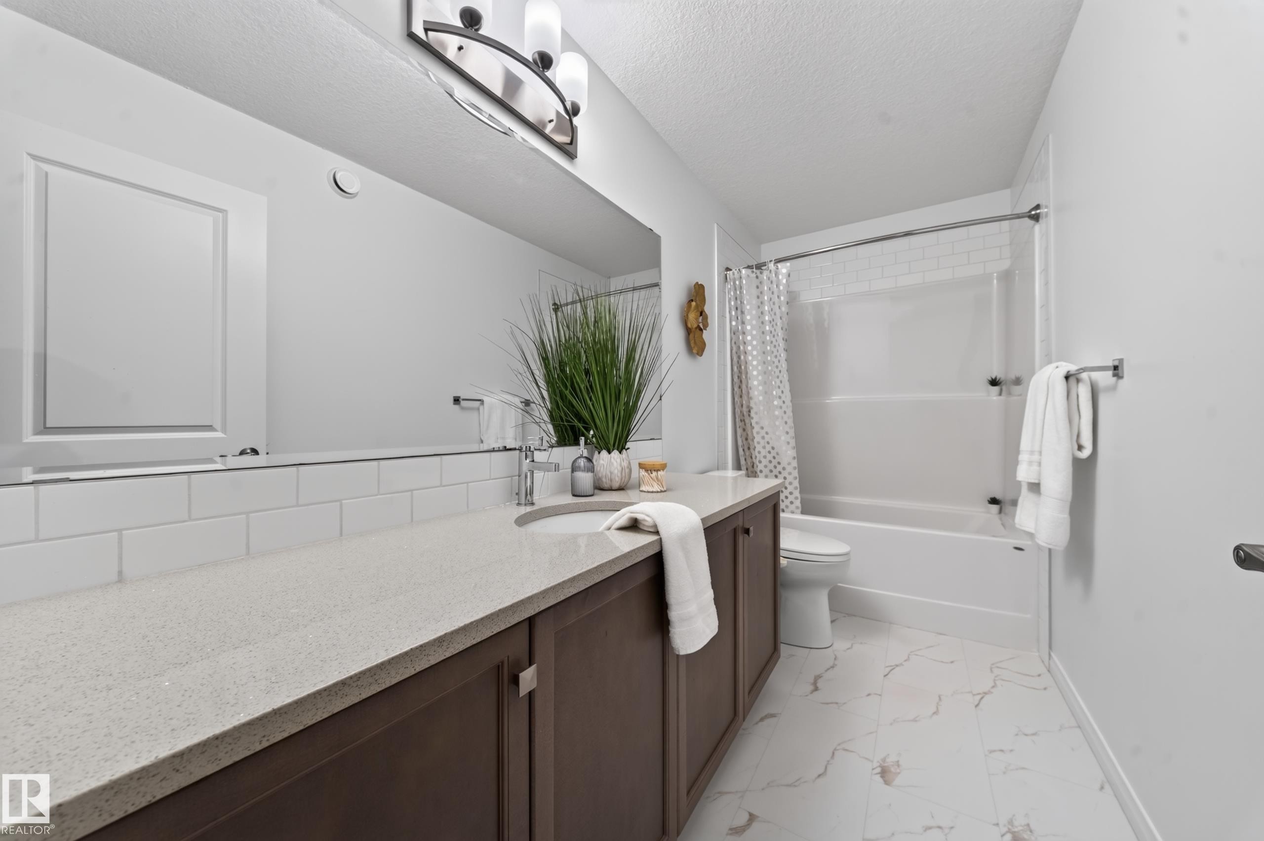 Vanity with light-toned countertop, undermount sink, and dark wood-finish cabinetry - 4104 3 Avenue Sw, Edmonton, AB