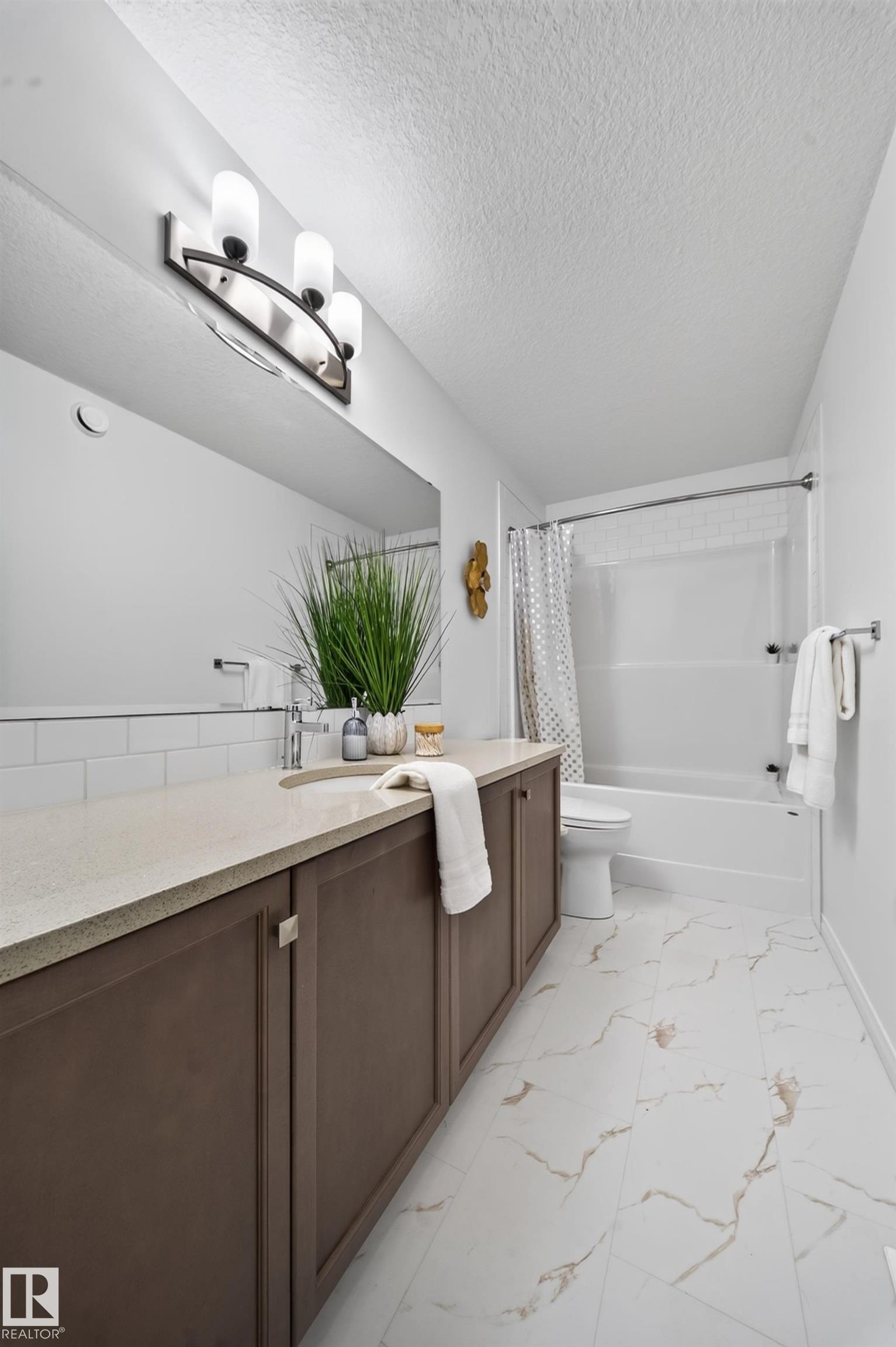 Brown cabinetry with metal hardware, light-toned countertop, rectangular undermount sink, and a tiled backsplash - 4104 3 Avenue Sw, Edmonton, AB