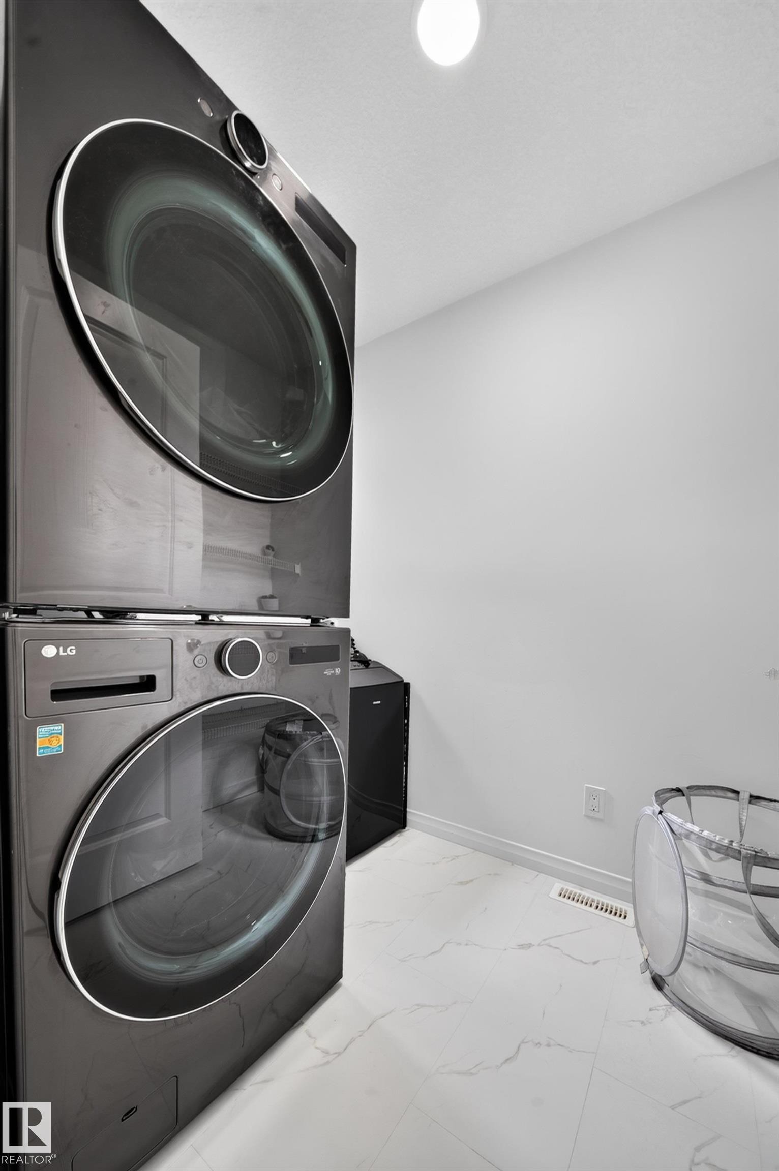 White walls with a single ceiling-mounted light fixture, paired with white tile flooring featuring a subtle gray veining pattern - 4104 3 Avenue Sw, Edmonton, AB