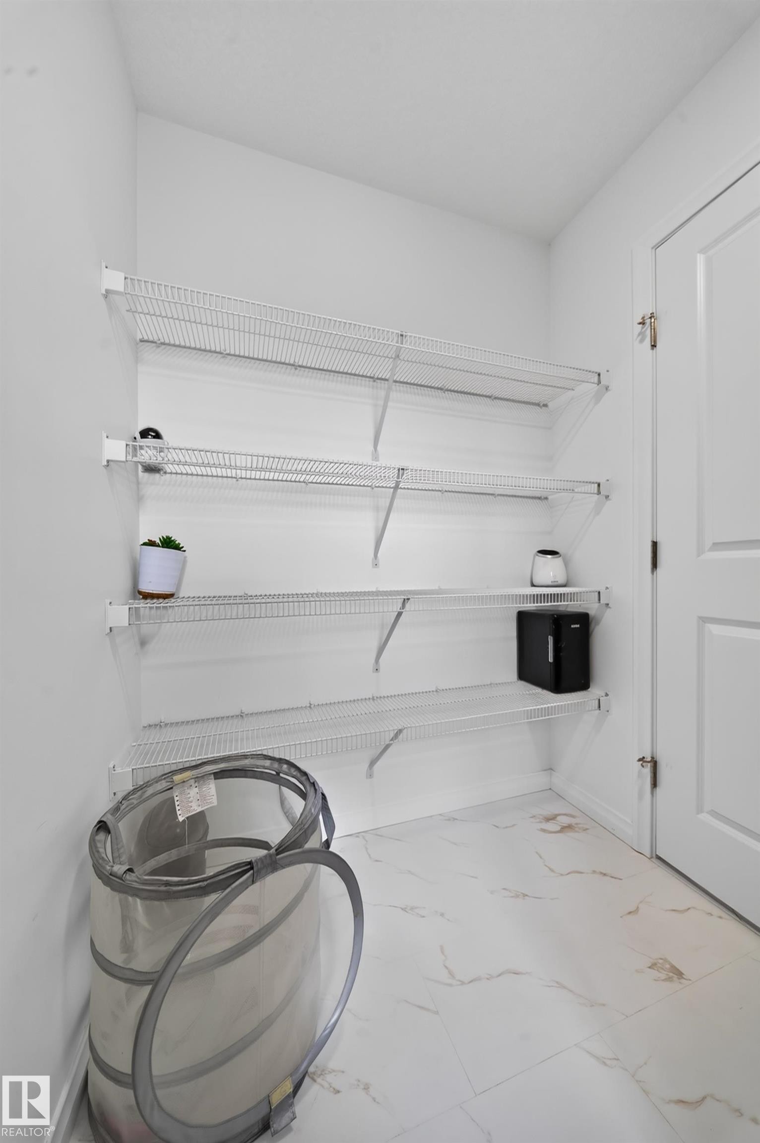 White wire shelving system, white interior walls, white paneled door, and tiled flooring - 4104 3 Avenue Sw, Edmonton, AB