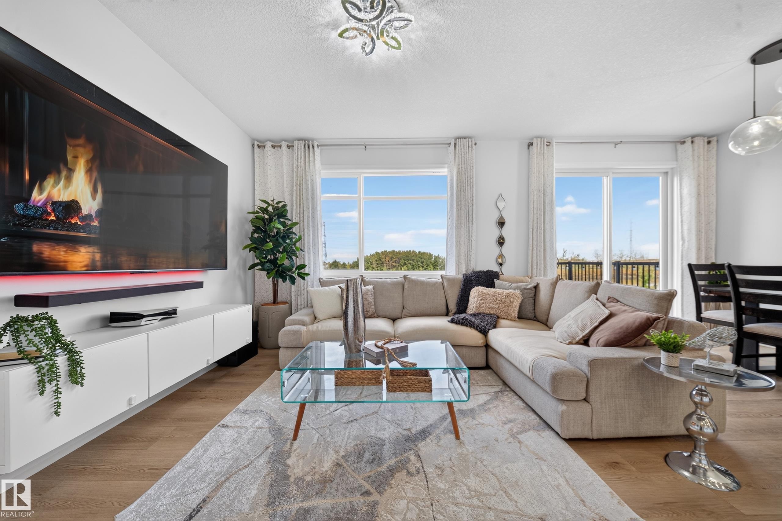 Hardwood-finish flooring throughout, featuring multiple large windows, and a ceiling-mounted light fixture - 4104 3 Avenue Sw, Edmonton, AB