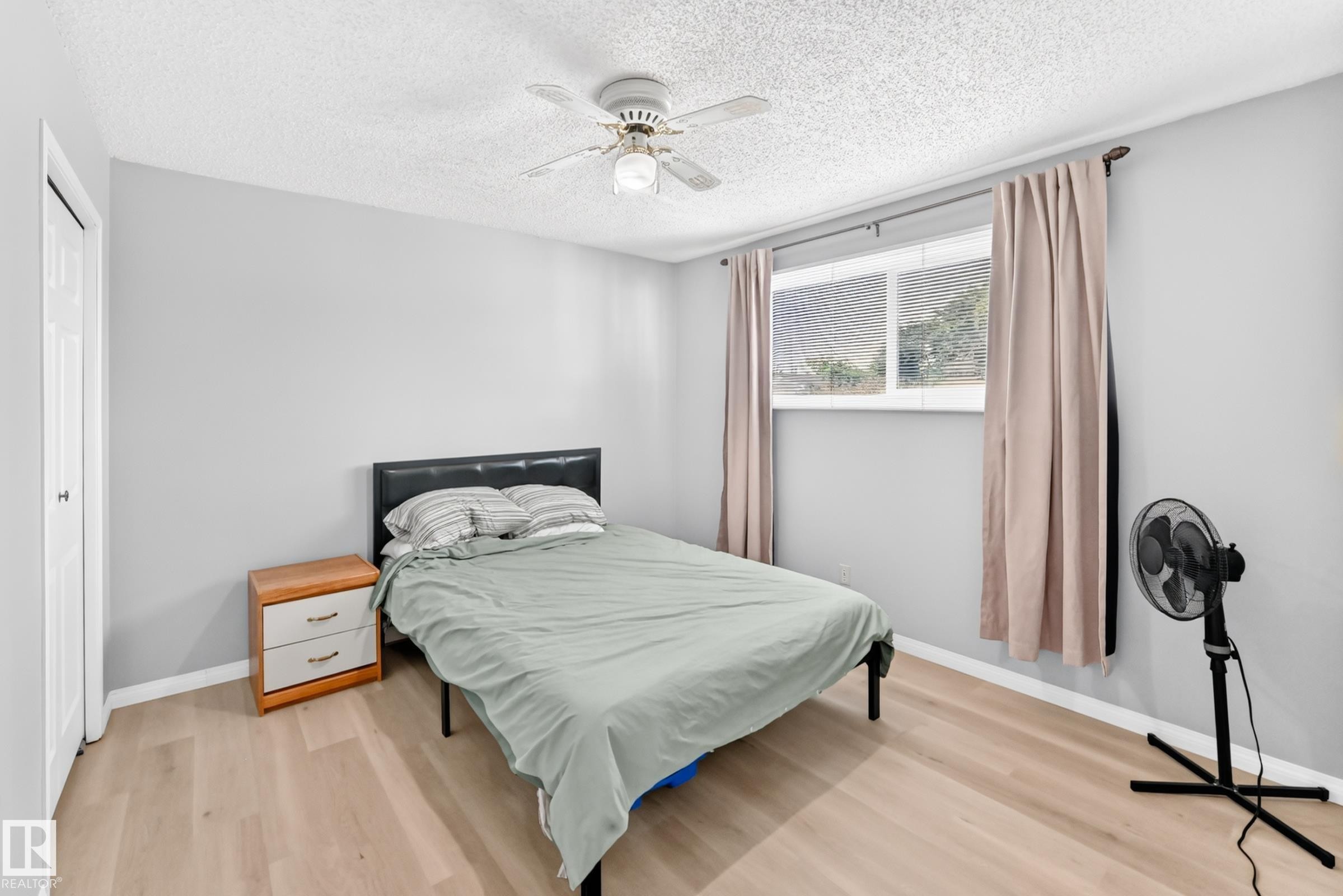 Light wood-finish flooring, a ceiling fan, and a double-pane window - 44 Habitat Crescent Nw, Edmonton, AB
