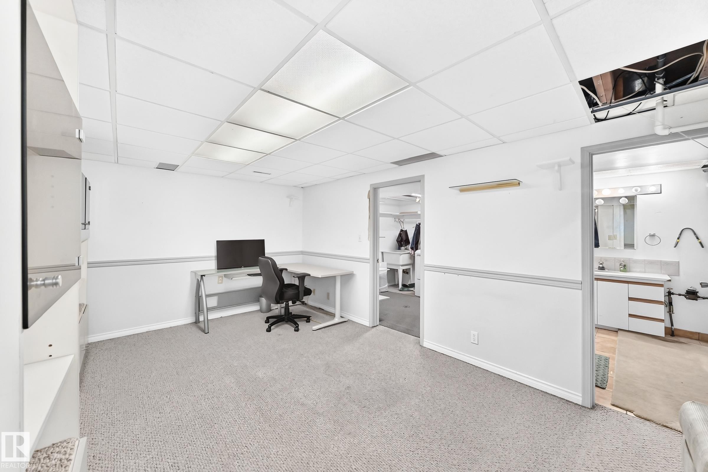 Carpeted room with drop ceiling, white walls, and built-in shelving - 44 Habitat Crescent Nw, Edmonton, AB
