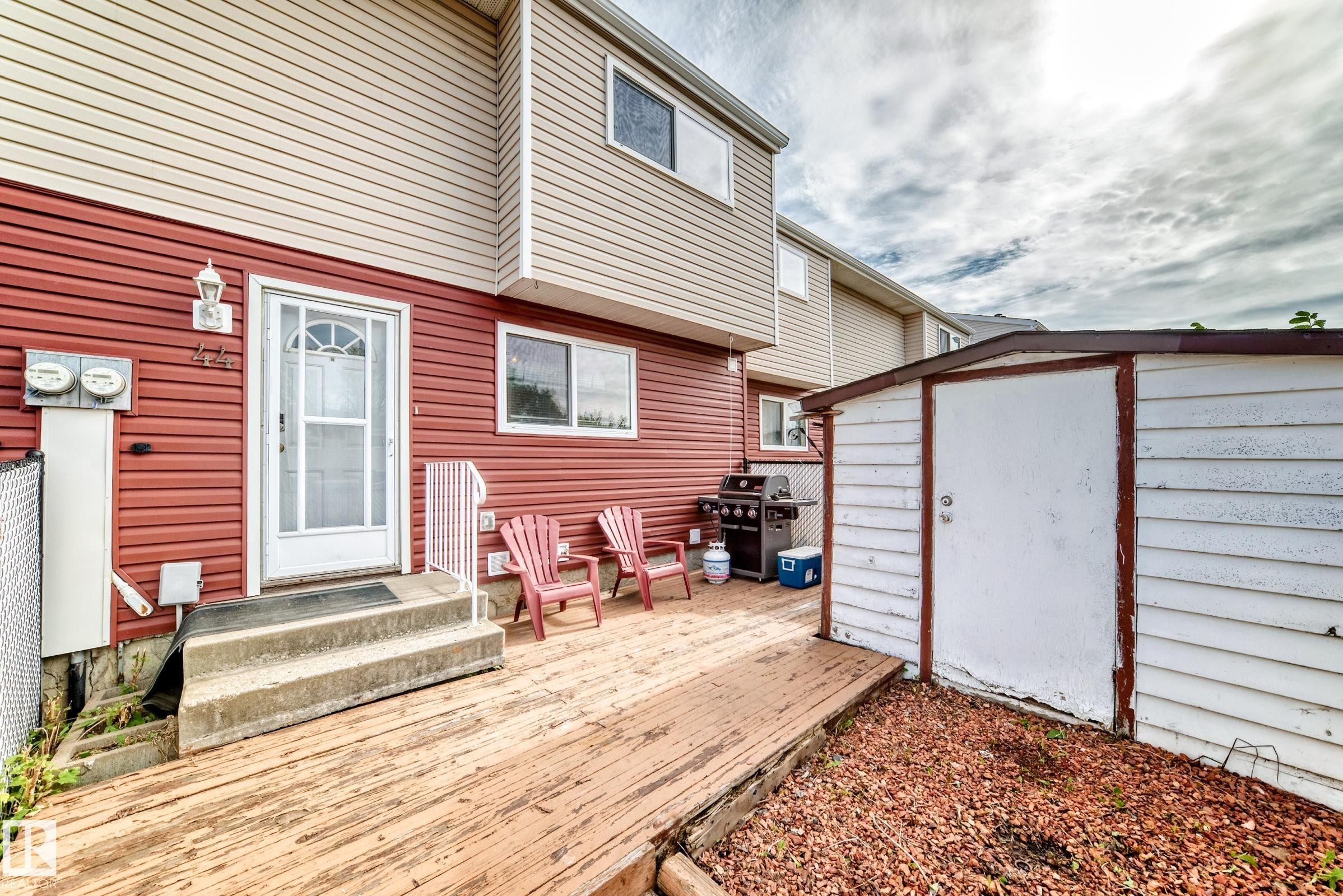Backyard featuring a wood deck, concrete steps, and a storage shed - 44 Habitat Crescent Nw, Edmonton, AB